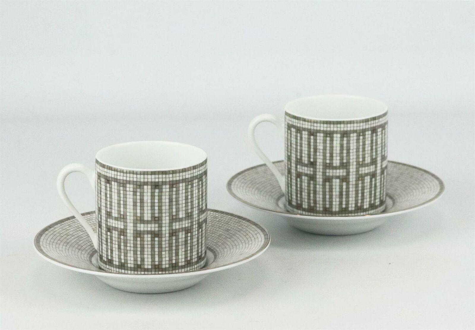 Set of 2 platinum, grey and white porcelain Hermès Mosaïque Au 24 coffee cup and matching saucer with tile design throughout, gilt accents and brand stamp on the bottom.
Does not come with box.

Dimensions: H 2.5 x D 2.25 inches.
Saucer: D 4.75