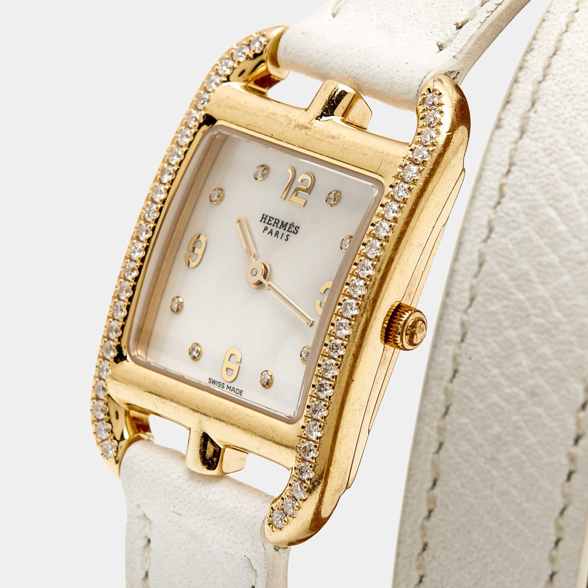 This women's wristwatch from Hermes will add a luxe touch to your everyday style. It is crafted from 18k yellow gold, and it has a mother-of-pearl dial and the perfect addition of diamonds, elevating its beauty. The watch is finished with a double