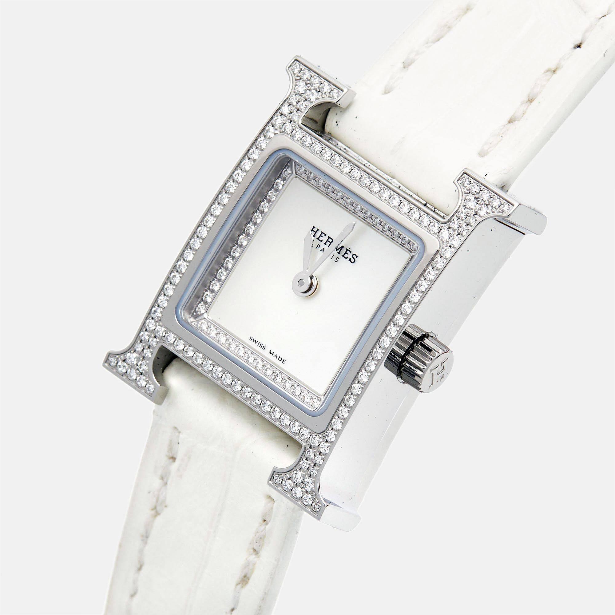 La montre Hermès Heure H est un chef-d'œuvre d'élégance et de luxe. Fabriquée avec une attention méticuleuse aux détails, elle présente un boîtier en acier inoxydable orné de diamants, complété par un superbe cadran en nacre. Le design emblématique