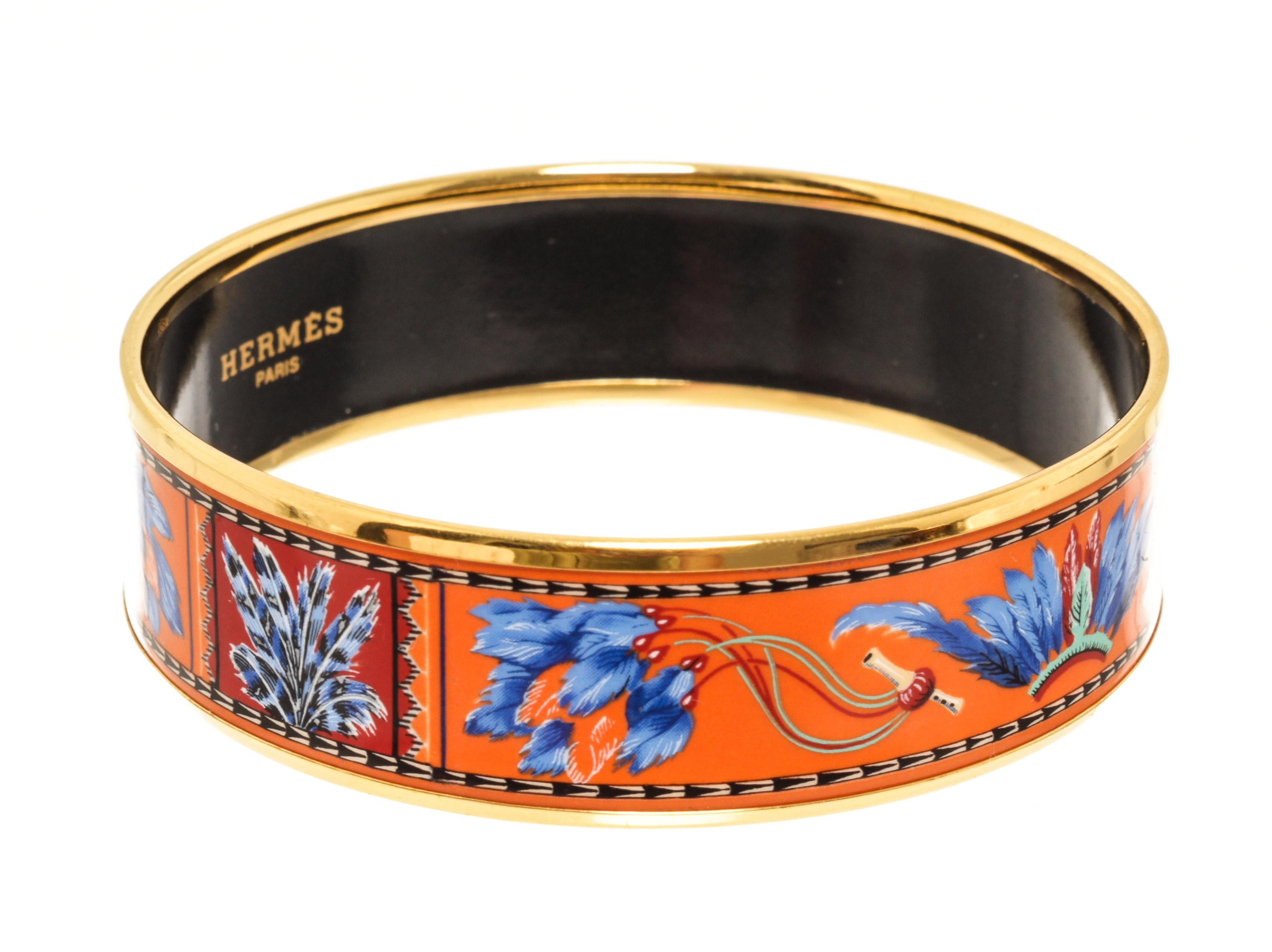 Hermes Multicolor Enamel Wide 65 Bangle Bracelet with pre-owned vintage hermes enamel bracelet with a blue, orange & turquoise printed feather design and yellow gold plated hardware.

79178MSC