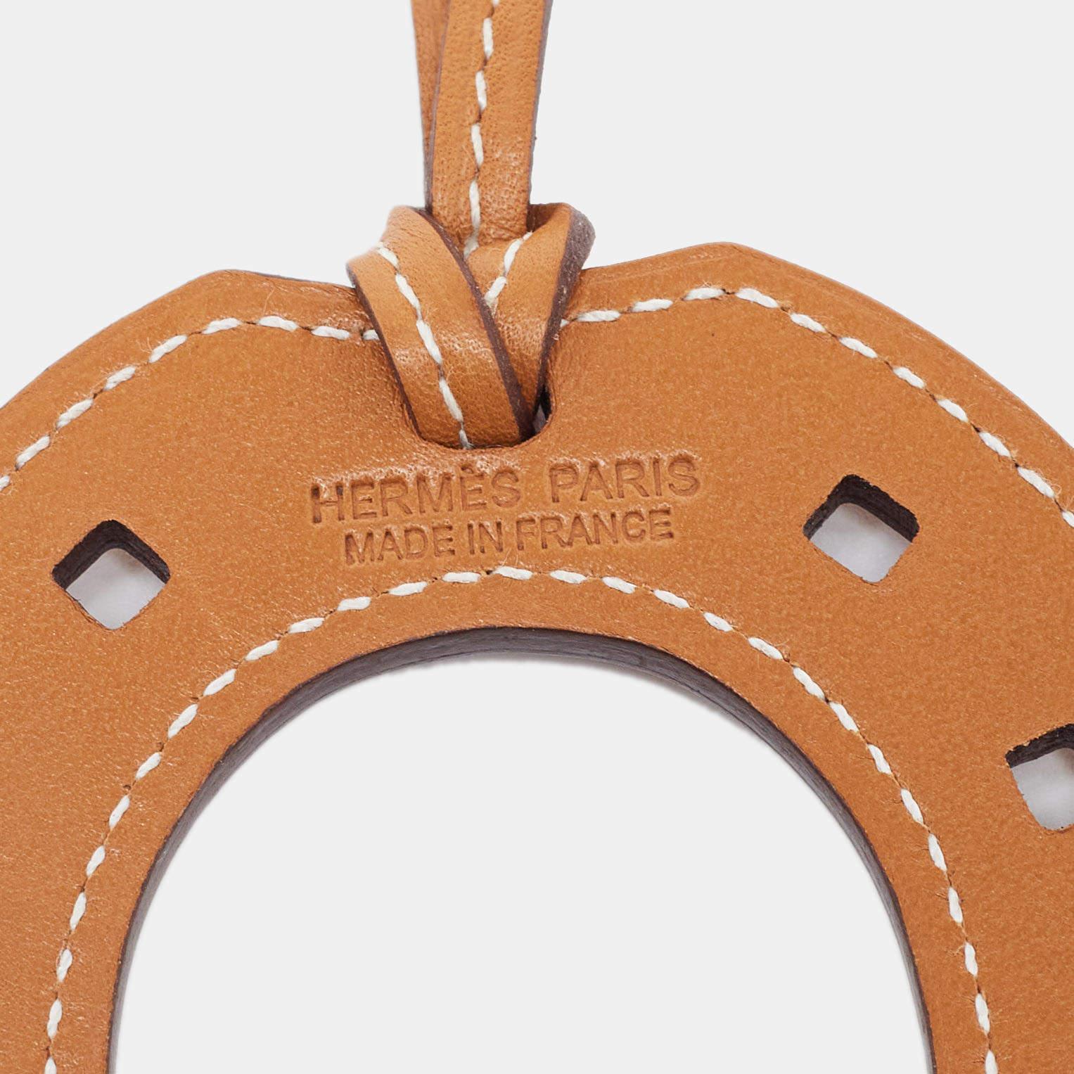 Paying homage to its equestrian heritage, this 'Paddock Fer a Cheval' bag charm from Hermès is a classy accessory to own. It is crafted using leather and hangs from a strap. Needless to say, this Hermès bag charm will add a signature touch to all