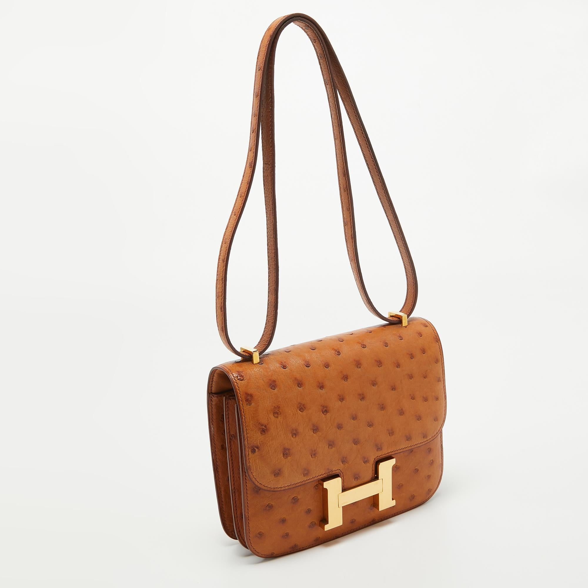 This Hermes Naturale Ostrich Constance III Mini is crafted using ostrich leather and features the iconic H clasp on the front flap. The shoulder strap lets you carry it gracefully, and the fine finish of the sturdy silhouette projects a luxe look.