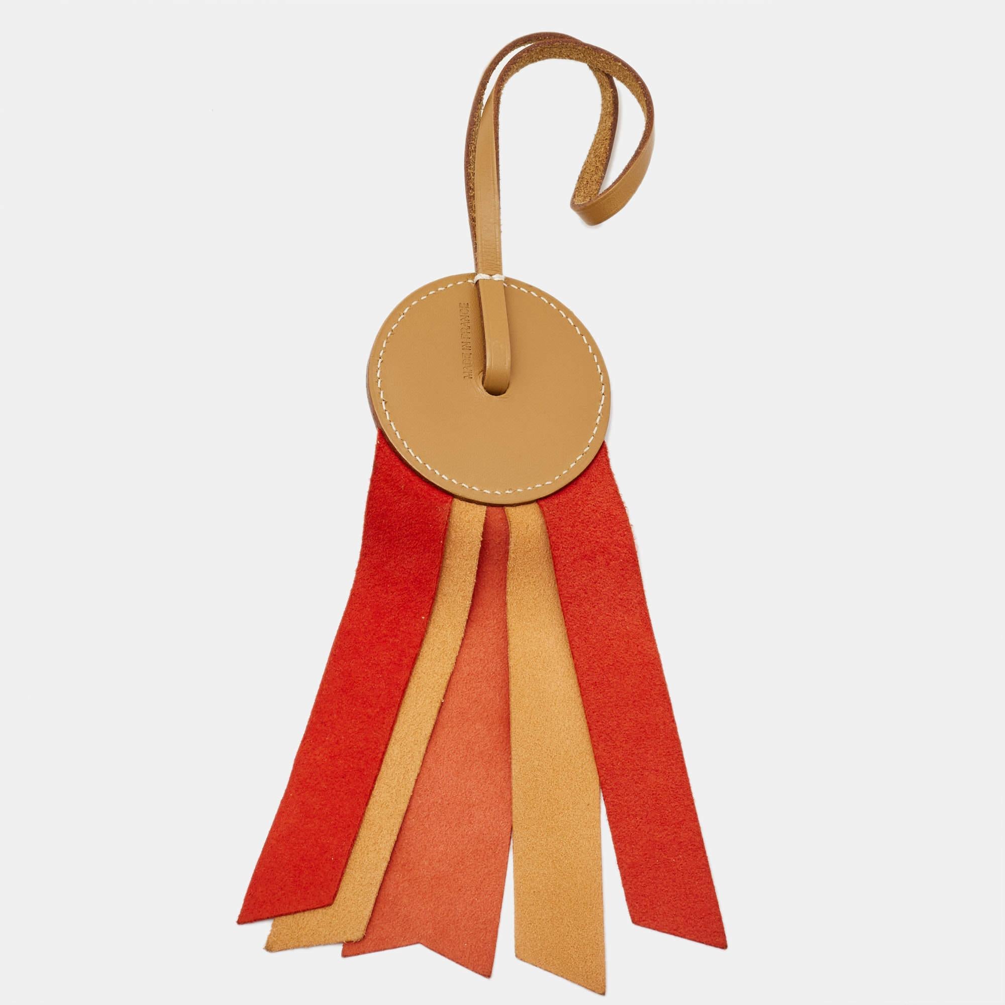 Lend your bag a luxe touch with this Hermes charm. It is made of leather a material the brand skillfully works with and has a few strips in lovely colors.