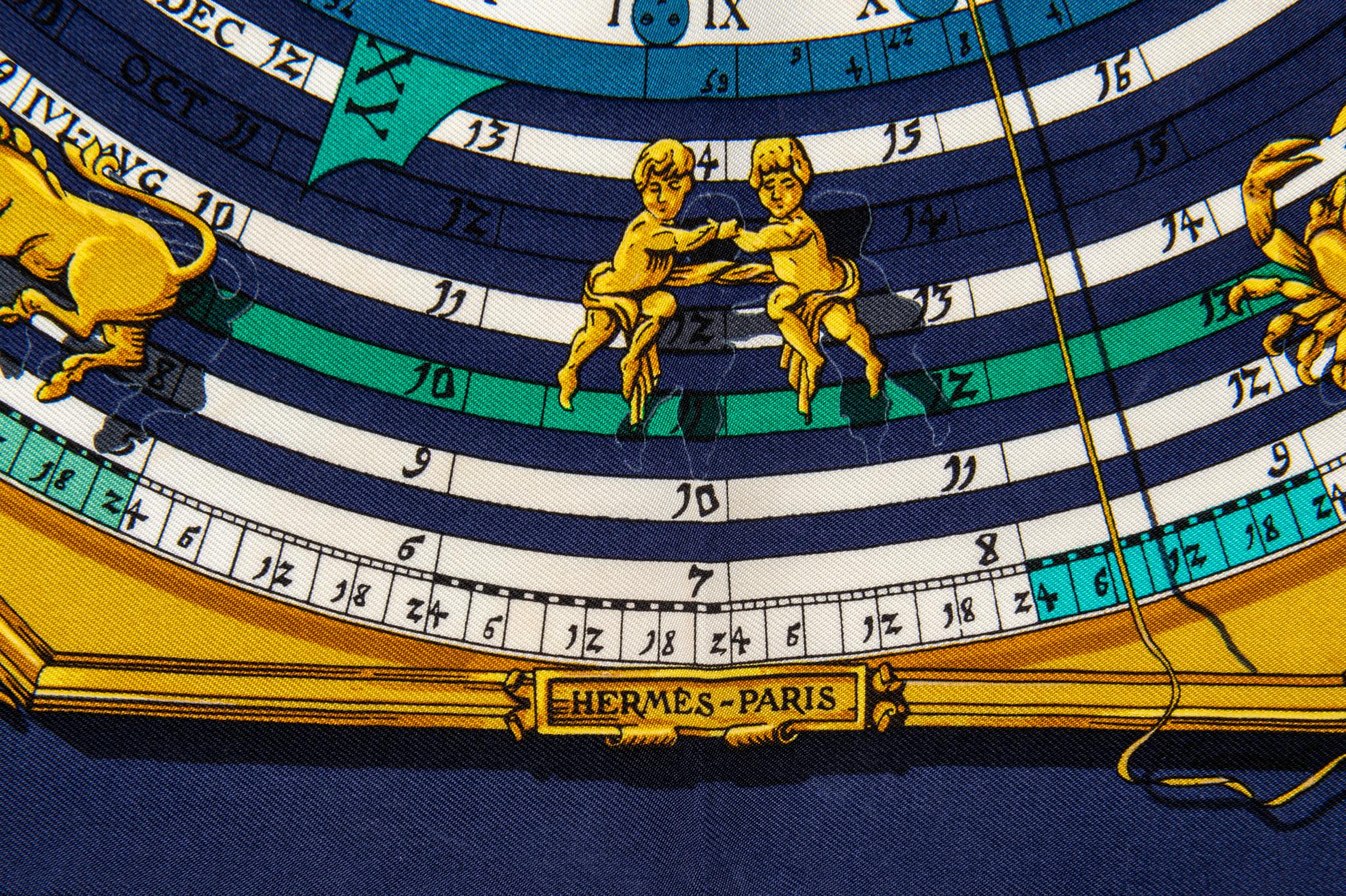 Hermès silk twill Astrologie scarf in navy with cream and gold accents. Hand-rolled edges. Minor wear.