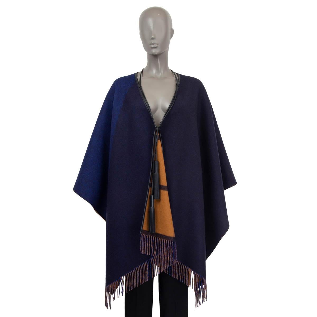 100% authentic Hermès 2022 Highlands reversible poncho in navy and camel merino wool (90%) and cashmere (10%). Features fringed details, a leather trim and two leather tassels at the front. Unlined. Has been worn once and is in virtually new