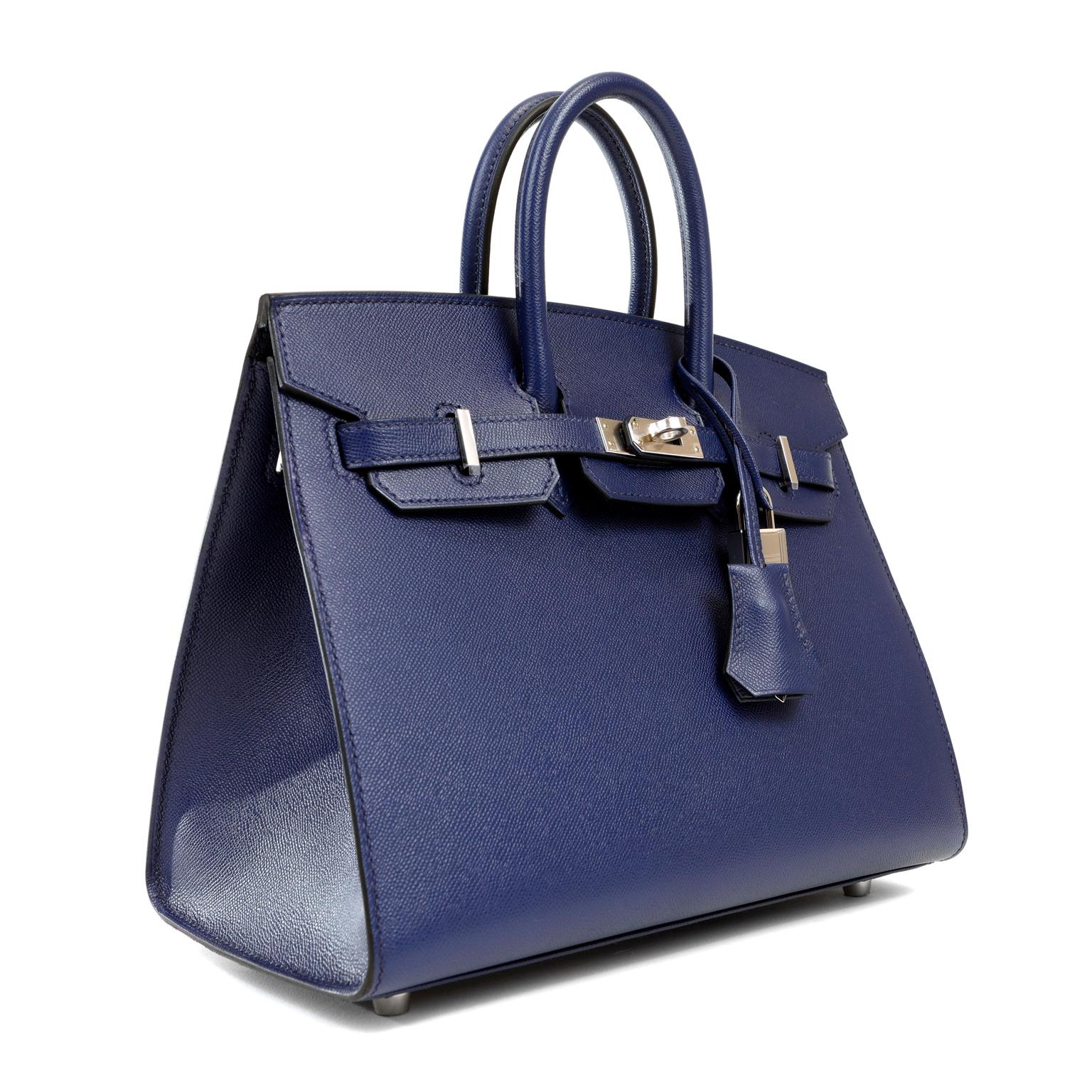 This authentic Hermès Navy Blue Epsom 25 cm Sellier Birkin is in pristine unworn condition; the protective plastic is still intact on the hardware.    Considered the ultimate luxury item, the Hermès Birkin is stitched by hand. Waitlists are