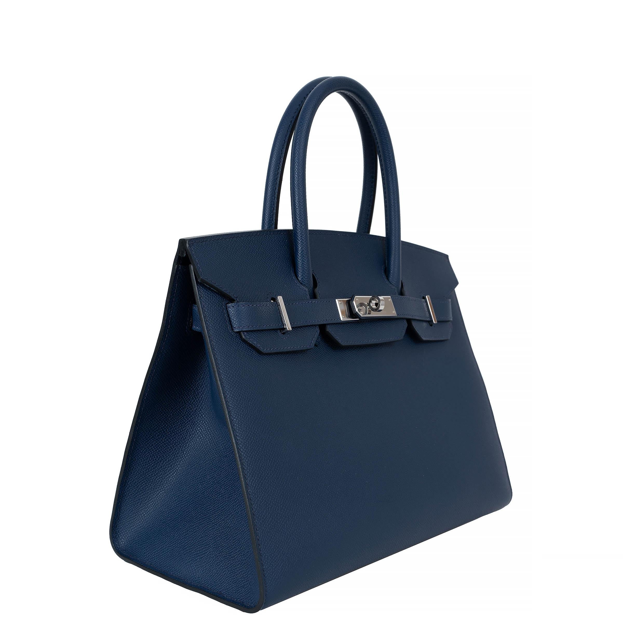 This 100% authentic Hermès Birkin 30 Sellier bag in navy blue Veau Epsom leather is a timeless icon of refined craftsmanship. Known for its structured silhouette and durability, the Epsom leather offers a sleek, elegant finish. Accented with