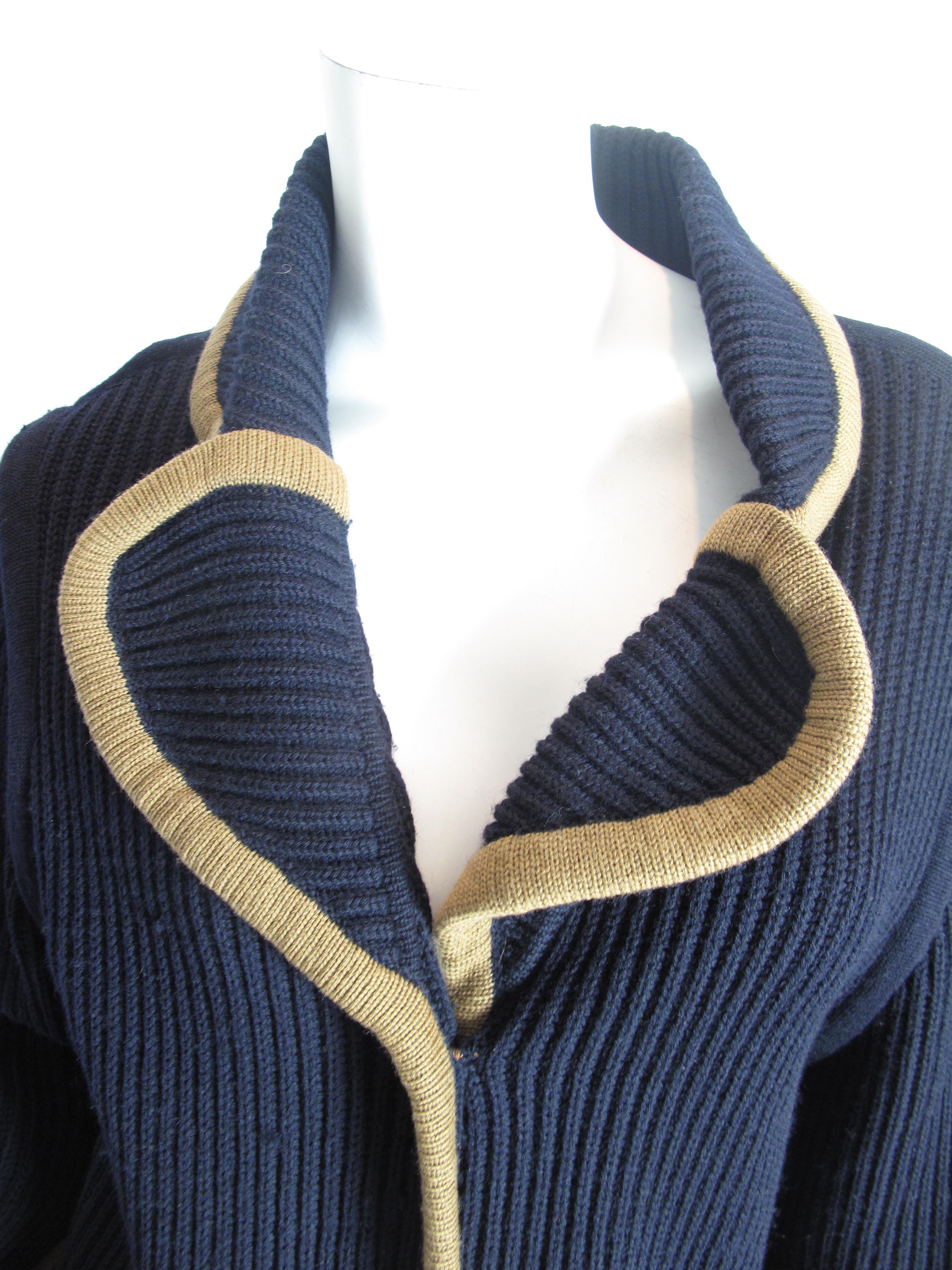 Hermes navy wool knit cardigan with tan trim, dual pockets and button closures at front.  Condition: Good, some small holes have been repaired. 

42