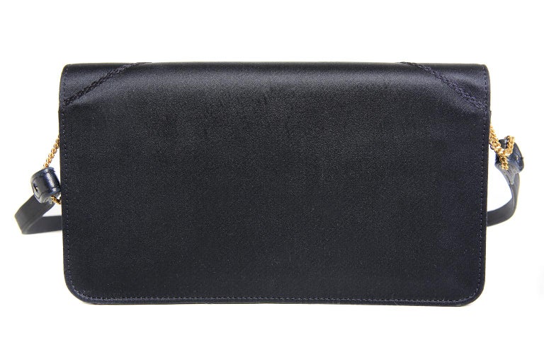 This authentic Hermès Navy Satin Evening Bag is in pristine condition, possibly carried one time. Beautifully designed, it can be held as a clutch or worn with a shoulder strap that easily connects via dainty gold chains. A beautiful bag on its own,