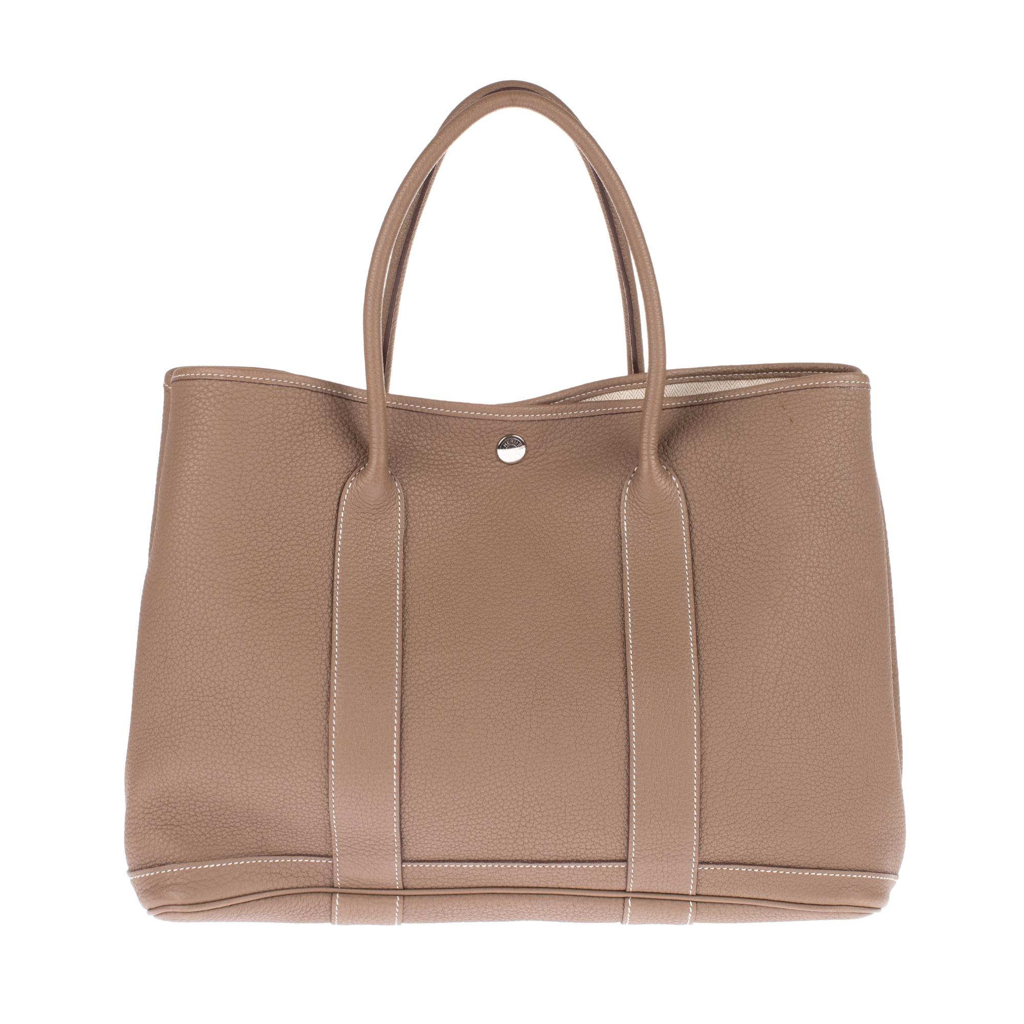 HERMES Negonda Garden Party 36 MM Etoupe.
This stylish tote is finely crafted of luxurious richly grained leather in étoupe. The shoulder bag features expandable sides with a snap, facing trim with white top stitching that transitions into rolled