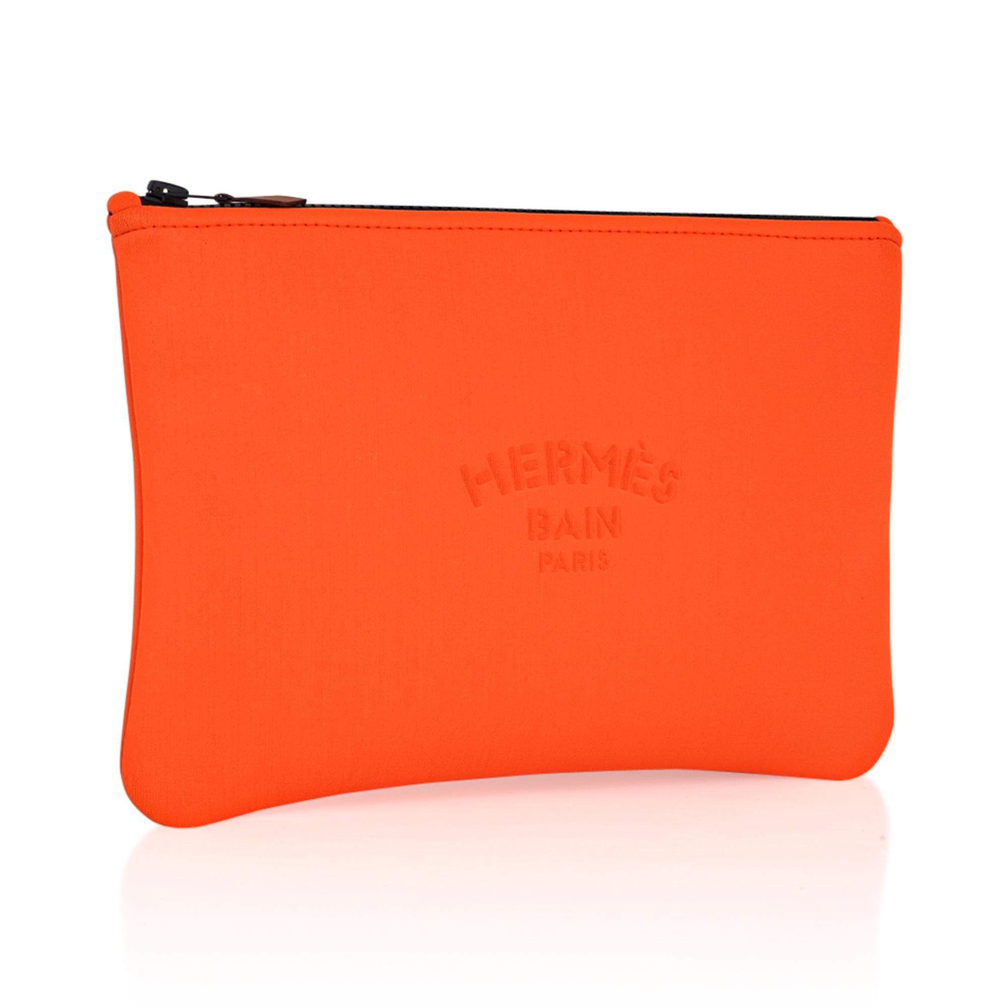 Mightychic offers an Hermes Neobain case featured in the small model.
Fun Neon Orange with Hermes Bain Pairs embossed on front.
Top zipper with leather zipper toggle.
Water repellent Polyamide and elastane makes this flat pouch a wonderful flat