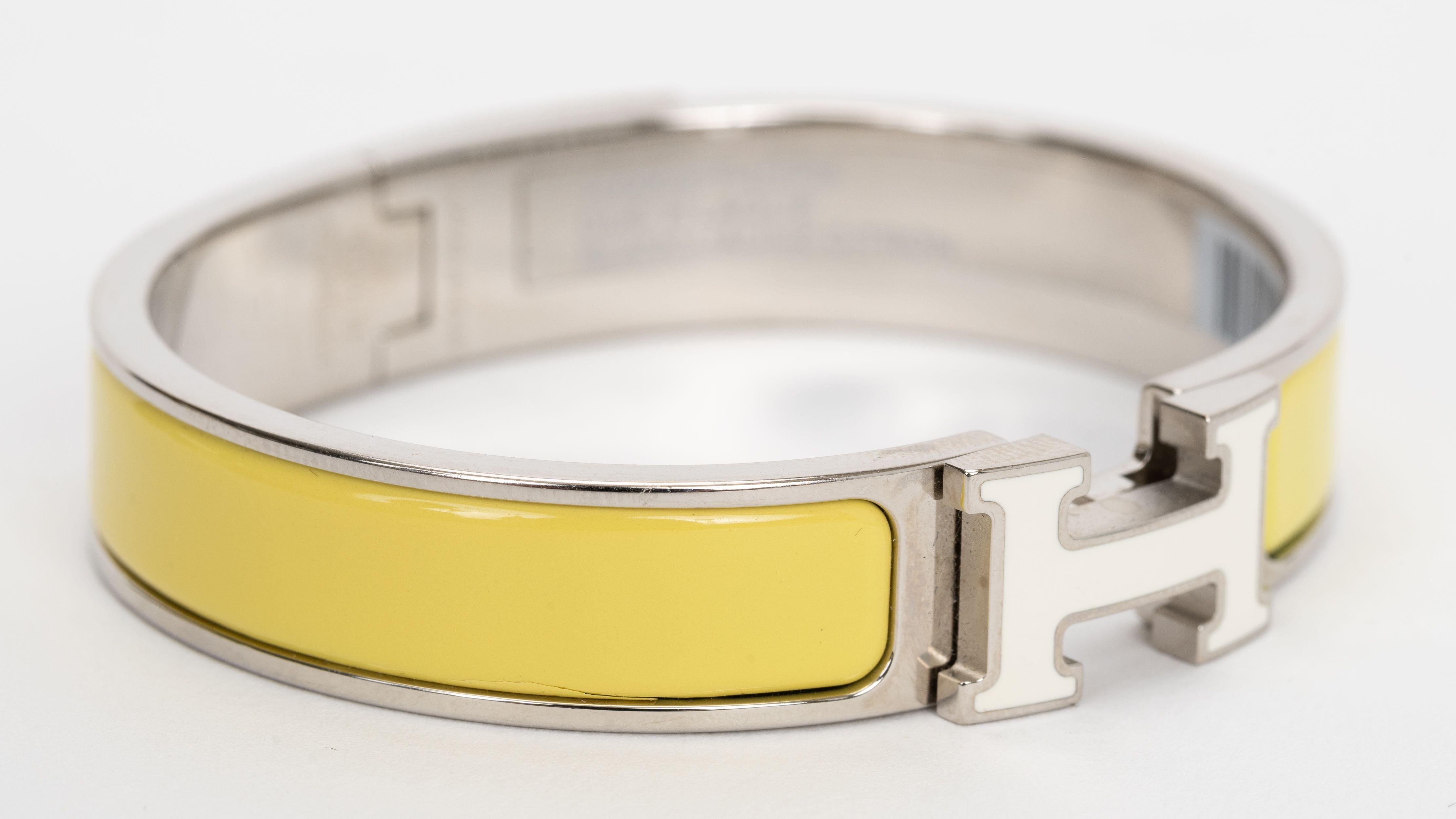 The Hermes Clic Clac H, narrow bracelet in jaune citron enamel, white enamel H with Palladium-plated hardware.
Size PM, new in unworn condition, comes with velvet pouch