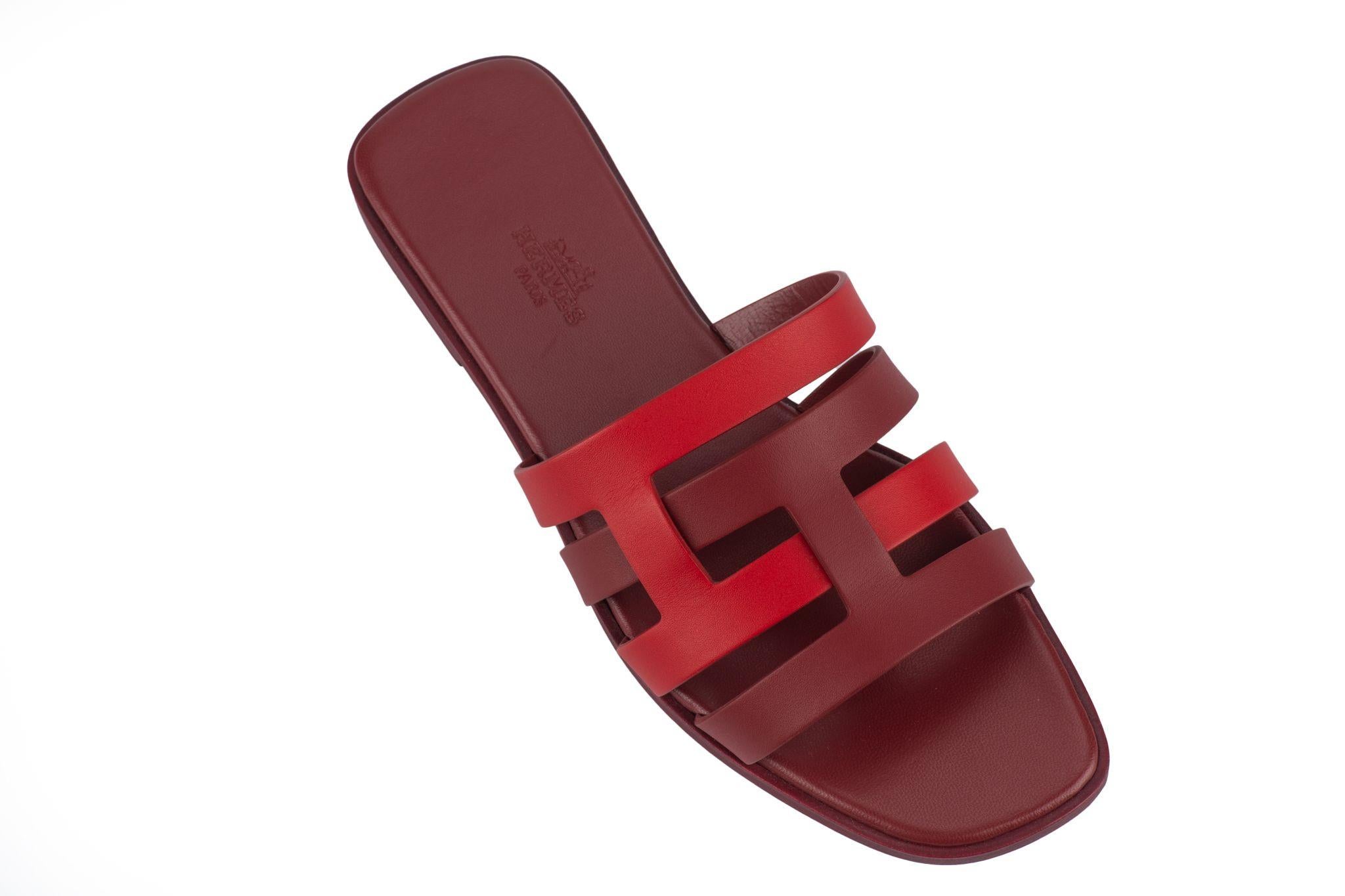 Hermès Amore Slides in Calfskin combination of rouge grenat and orange solaire. These classic sandals feature two intertwined initials and straight cut edges. Italian size 38, US 7.
Brand new with double dustcover and original box.