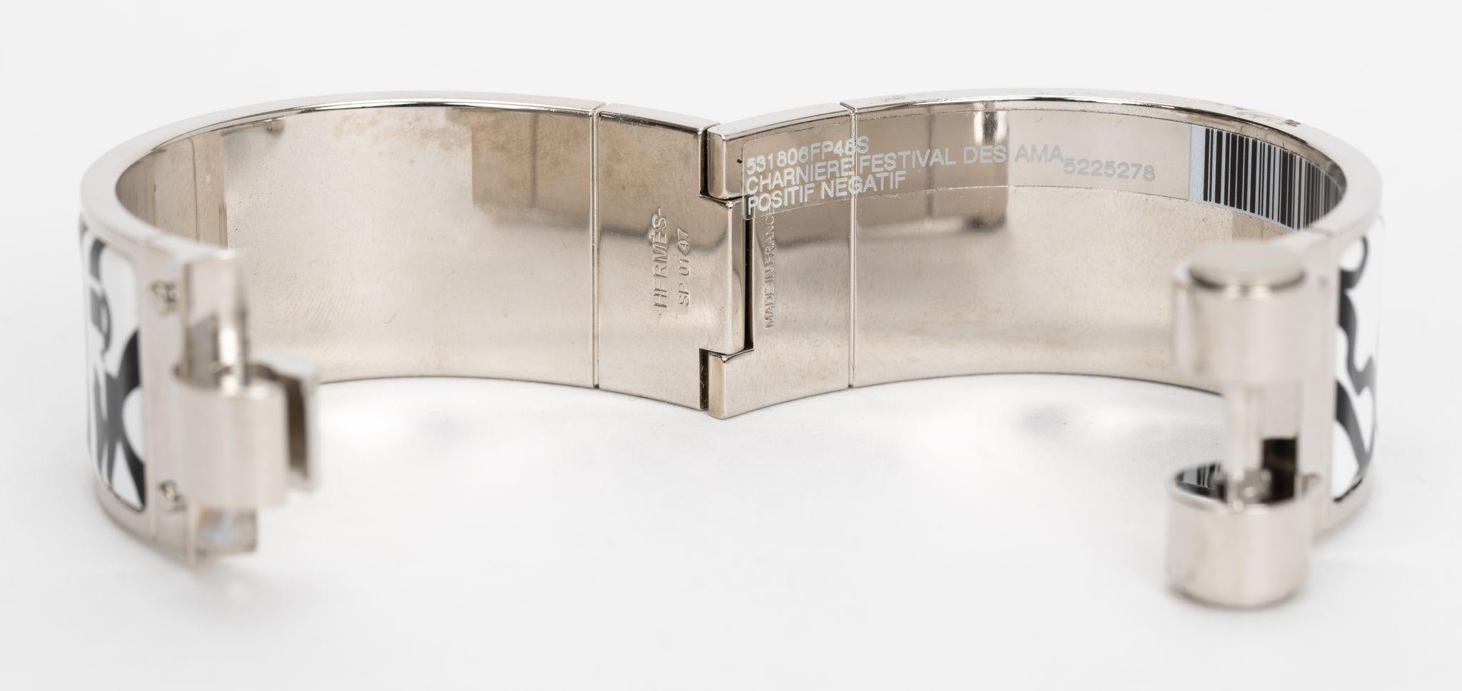 Das Hermes Charniere Scharnierarmband hat einen Körper aus bedruckter Emaille und Silberpalladium. Positiver/negativer Druck. Die schöne Silhouette ist mit einem Druckverschluss versehen. Brandneu in unbenutztem Zustand, Originalaufkleber noch
