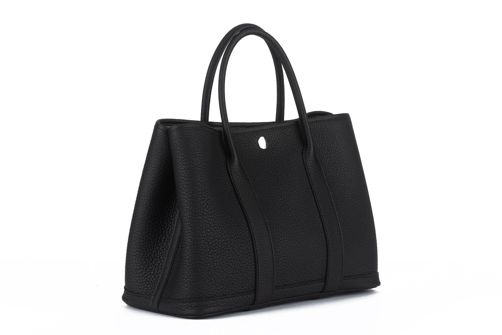 This Hermès Garden Party features black negonda leather and palladium hardware, with rolled handles, snap closures at the side and top, interior toile H canvas, and a single interior pocket.
Date Stamp - W, 2024. Brand new, comes with booklet,