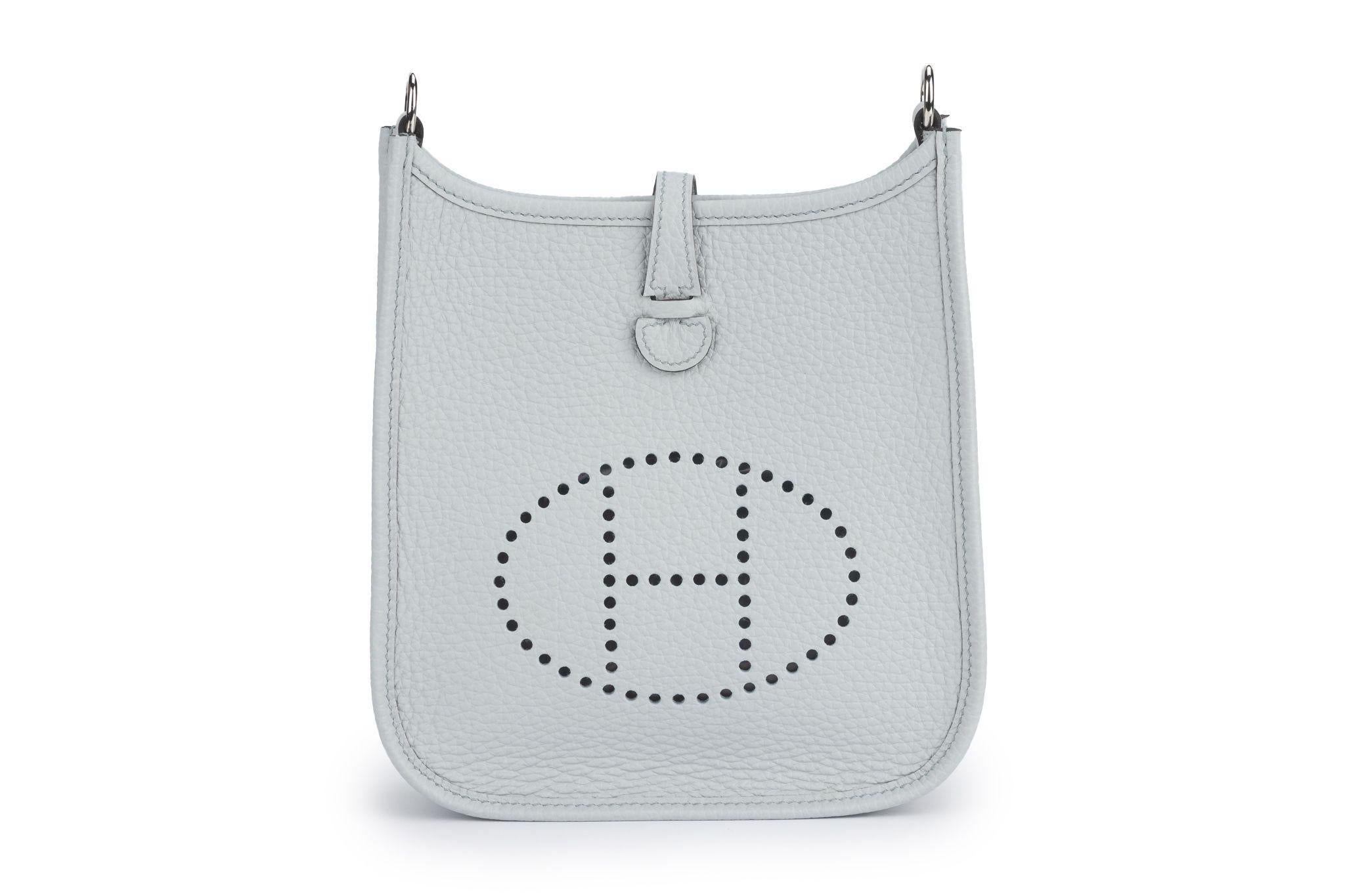 Hermes brand new in unused condition grey Mini Evelyne in Clemence leather with Palladium hardware. The perfect bag to wear crossbody throughout the day. Shoulder Strap 22