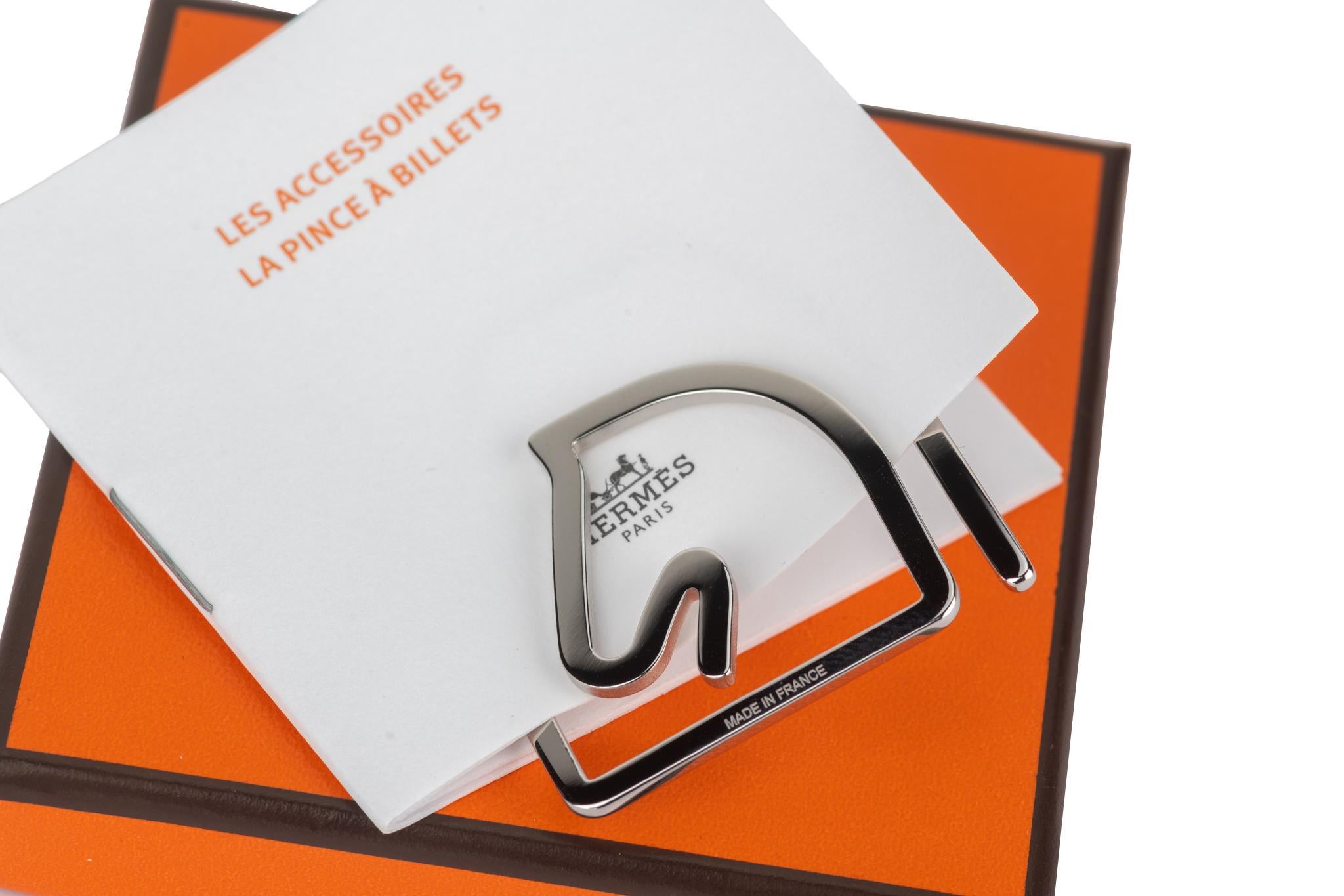 Il fermaglio per banconote Hermès Equestre è caratterizzato da una testa di cavallo in palladio che consente di conservare facilmente le banconote. Viene fornito con  nastro, copertina originale e scatola. Nuovo di zecca in condizioni inutilizzate.