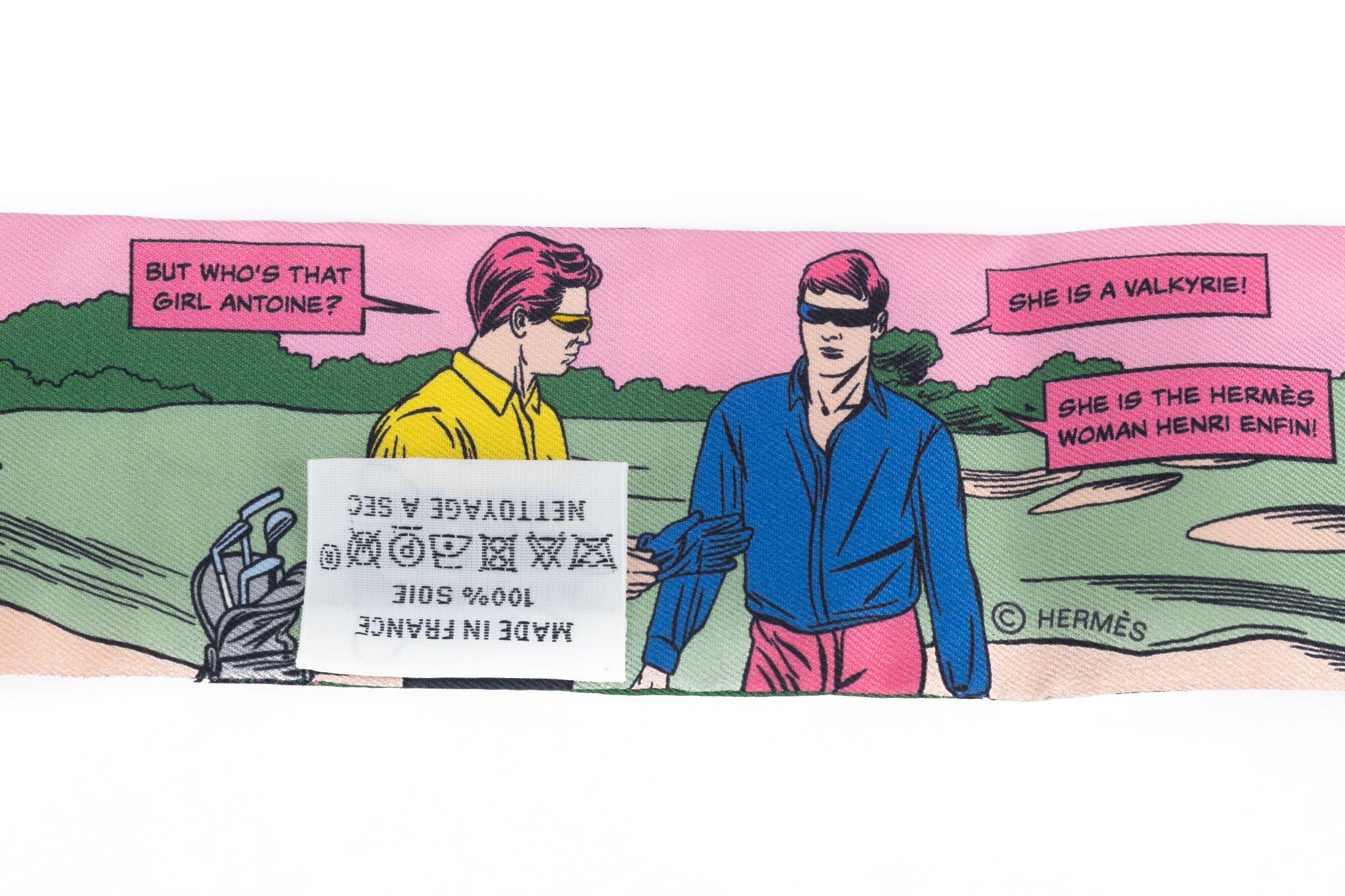 Twilly d'Hermès avec un motif comique dans les couleurs rosé et rose. La bande dessinée raconte l'histoire de Superwoman. L'écharpe est neuve et livrée avec sa boîte d'origine.