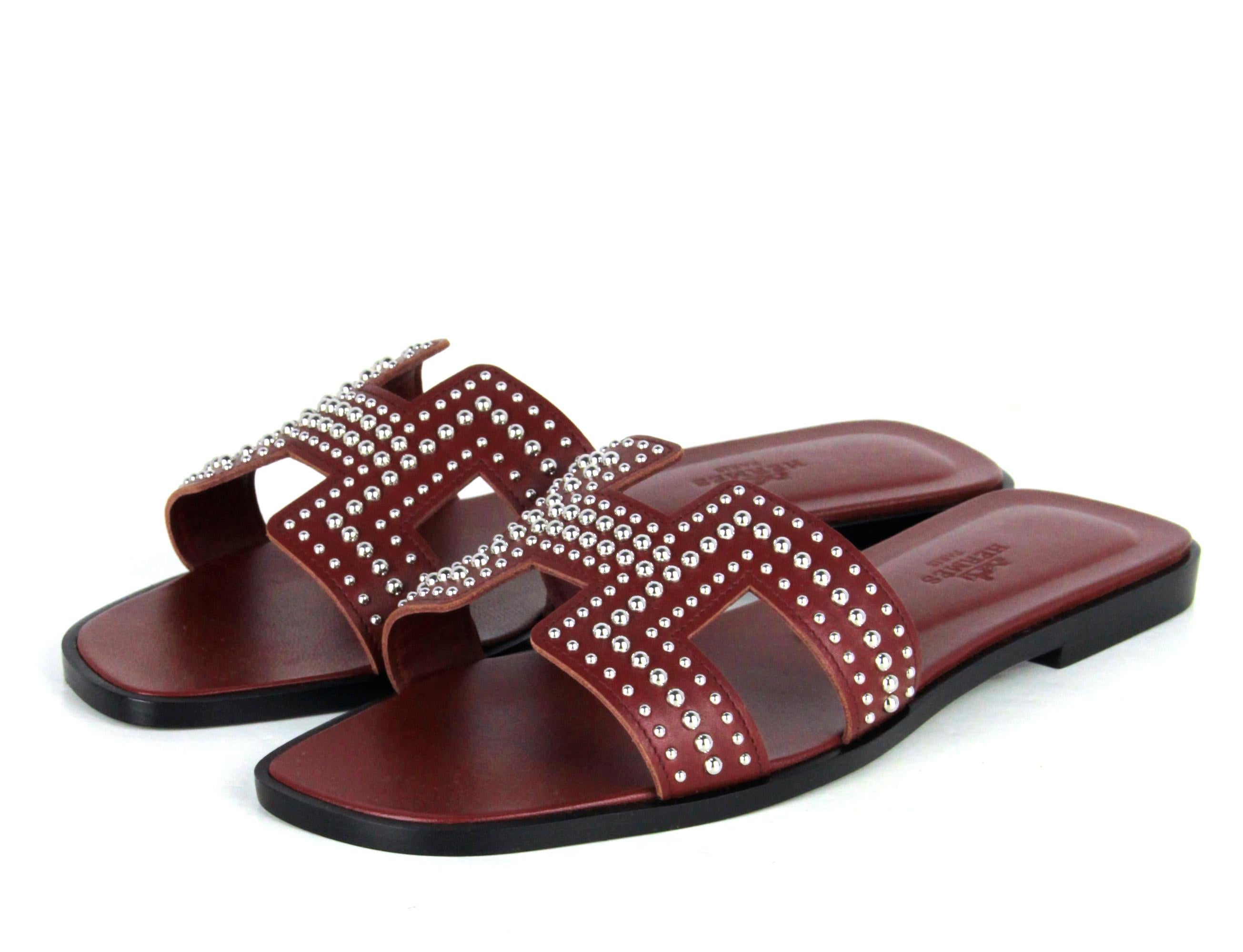Hermes Rouge Tomette Oran Studs Slide Sandals sz 37.5

Made In: Italy
Year of Production: 2021
Color: Rouge tomette burgundy
Materials: Leather and metal
Closure/Opening: Slip-on
Overall Condition: New
Estimated Retail: Hermes box and two
