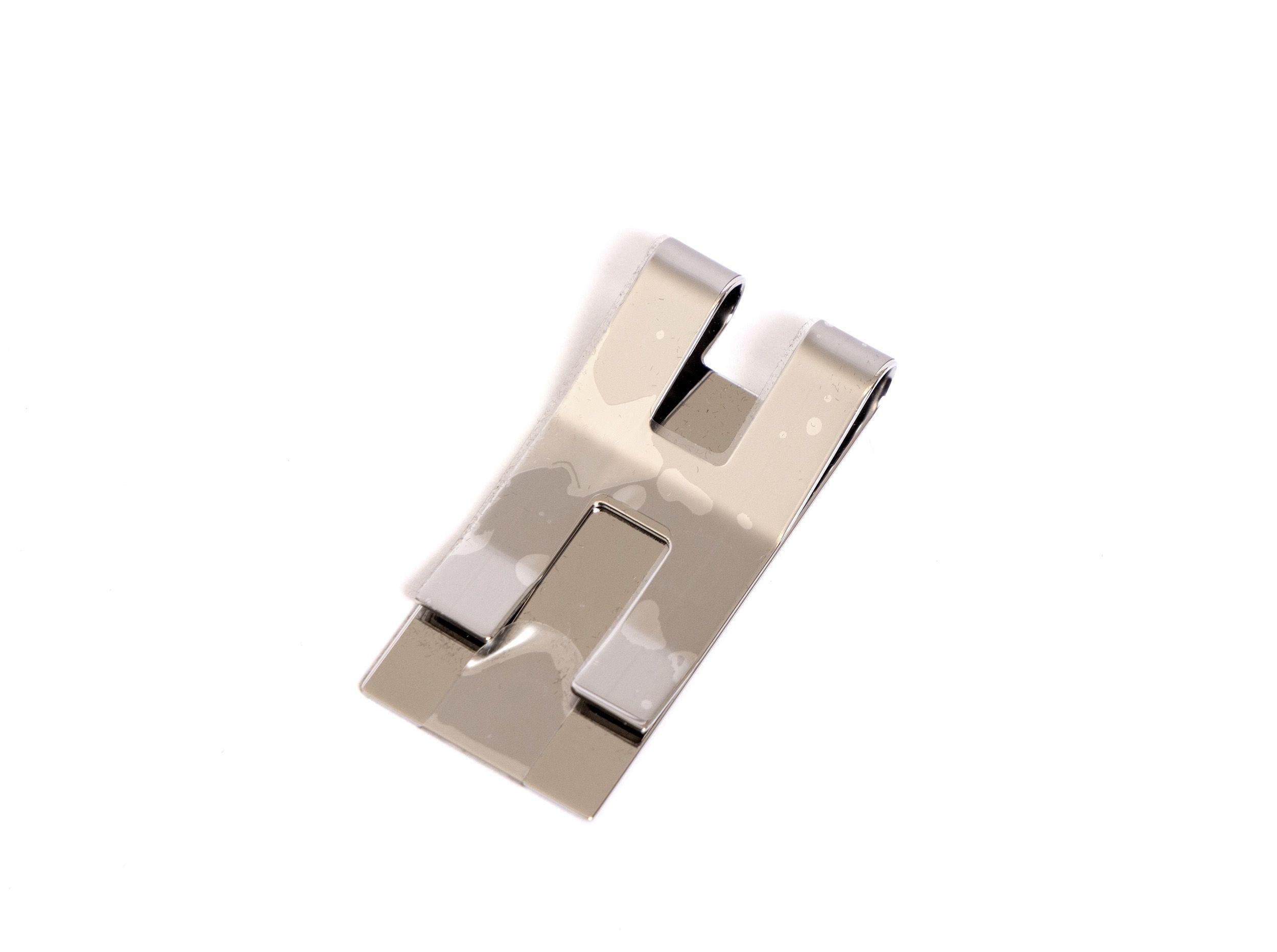 Hermes stainless steel metal H logo money clip. New in box. Comes with booklet, original pouch, box and ribbon. Money in picture not included. 
Pouch is made of toile and not of suede like in the photo.