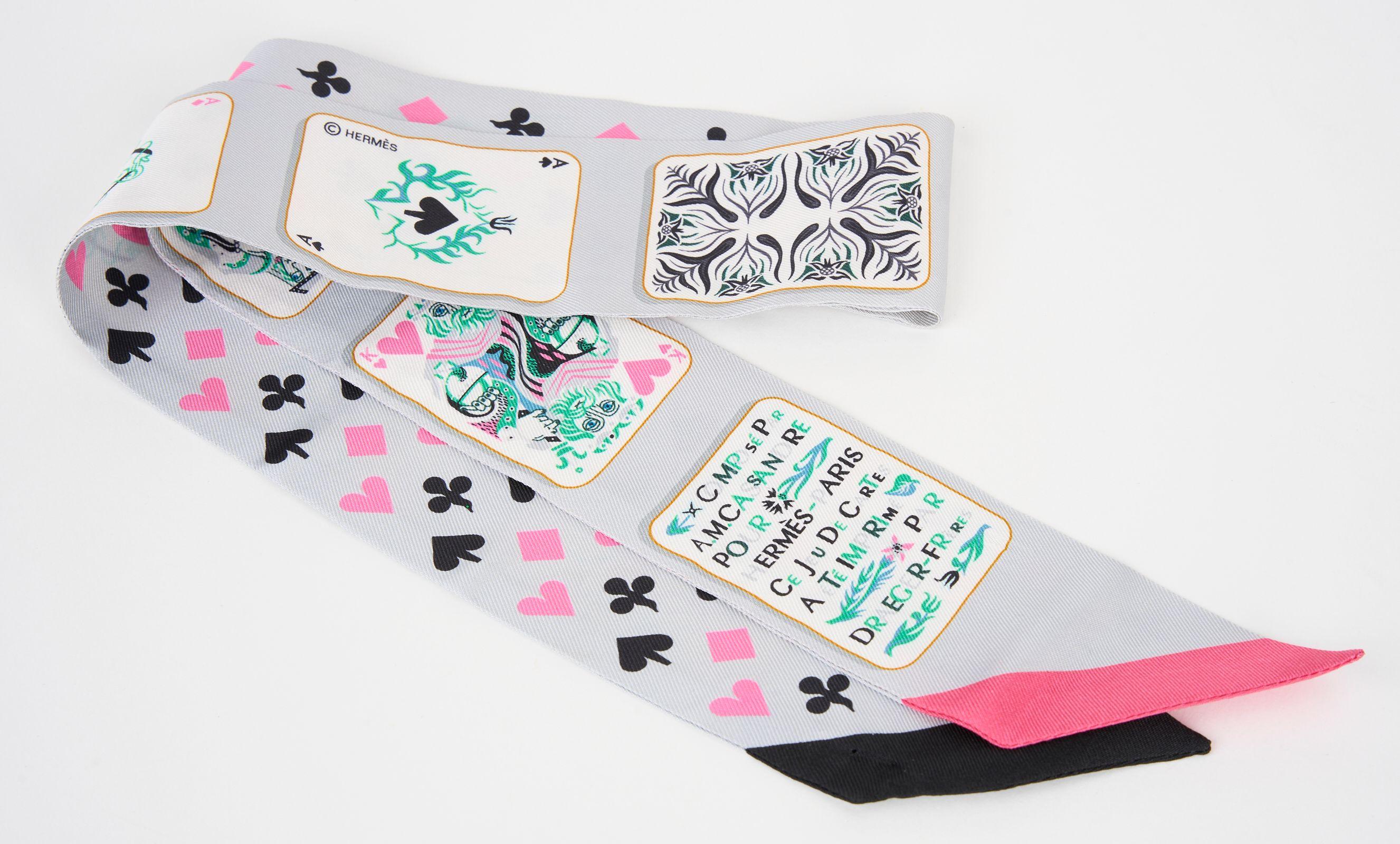 This Hermès Jeu de Cartes Twilly in Gris, Rose, and Black is made from 100% silk. Featuring a playful card design it is playfully perfect. It can be worn in different ways with a slide medor in palladium hardware. Comes with original box. Brand new.