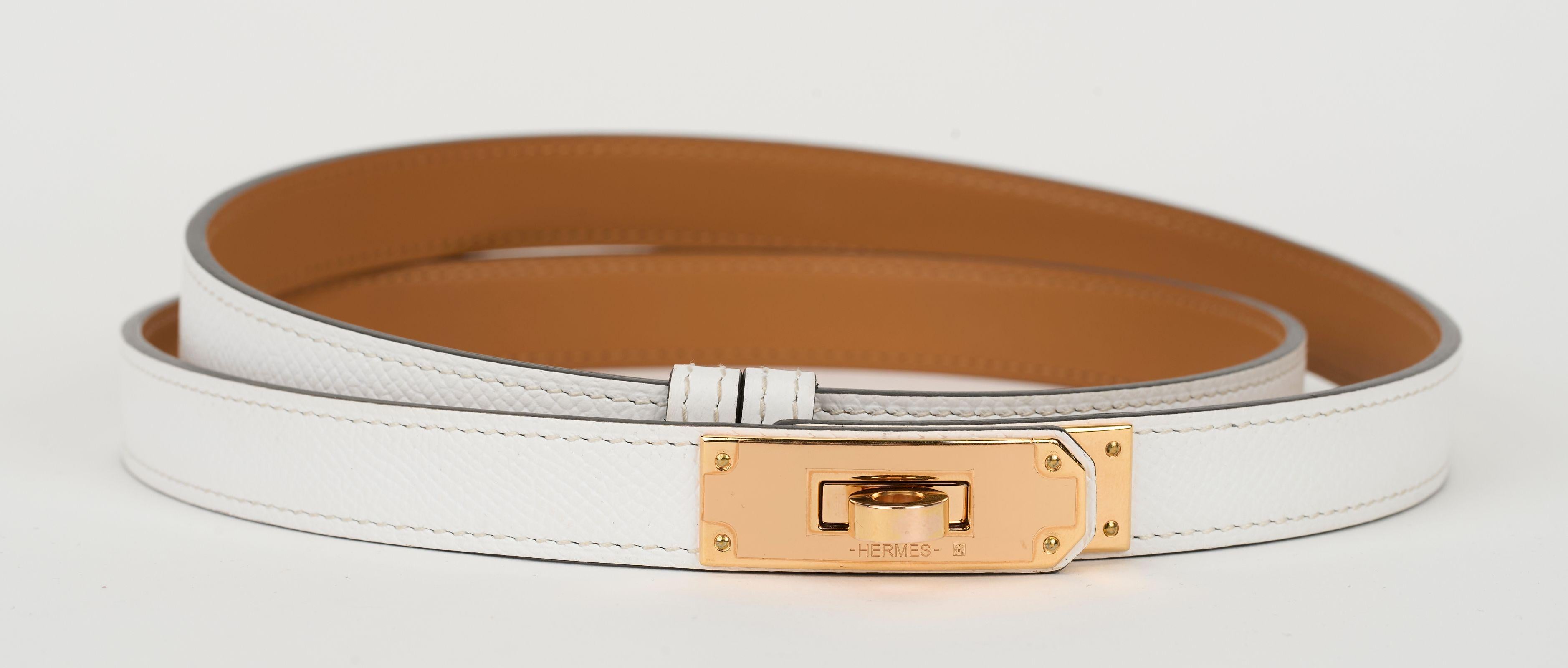 Hermès white leather belt in Epsom calfskin with rose gold kelly buckle. Plastic on hardware.
Thanks to a clever sliding system, this one-size-fits-most belt may be worn at the waist or on the hips. Adjustable size from 23.6