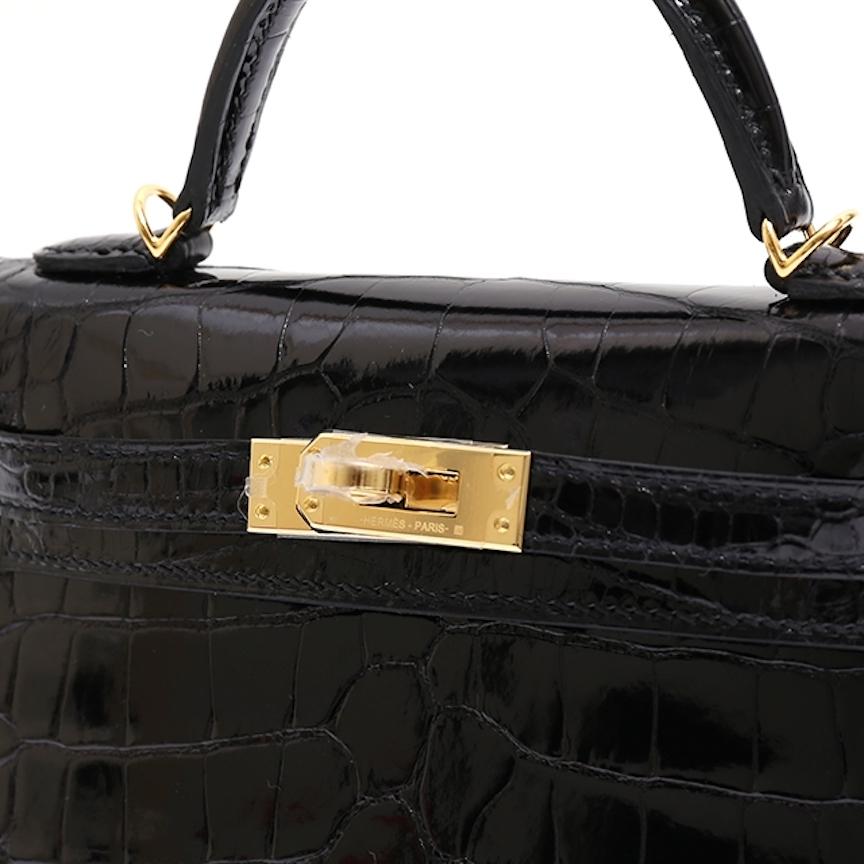 The Gets No Better Than This.  

This rare Hermes Alligator Kelly 20 bag is the ultimate status symbol for only the most serious of Hermes collectors. Crafted of exotic alligator skin leather and gold hardware, this bold, black, Hermes Kelly is