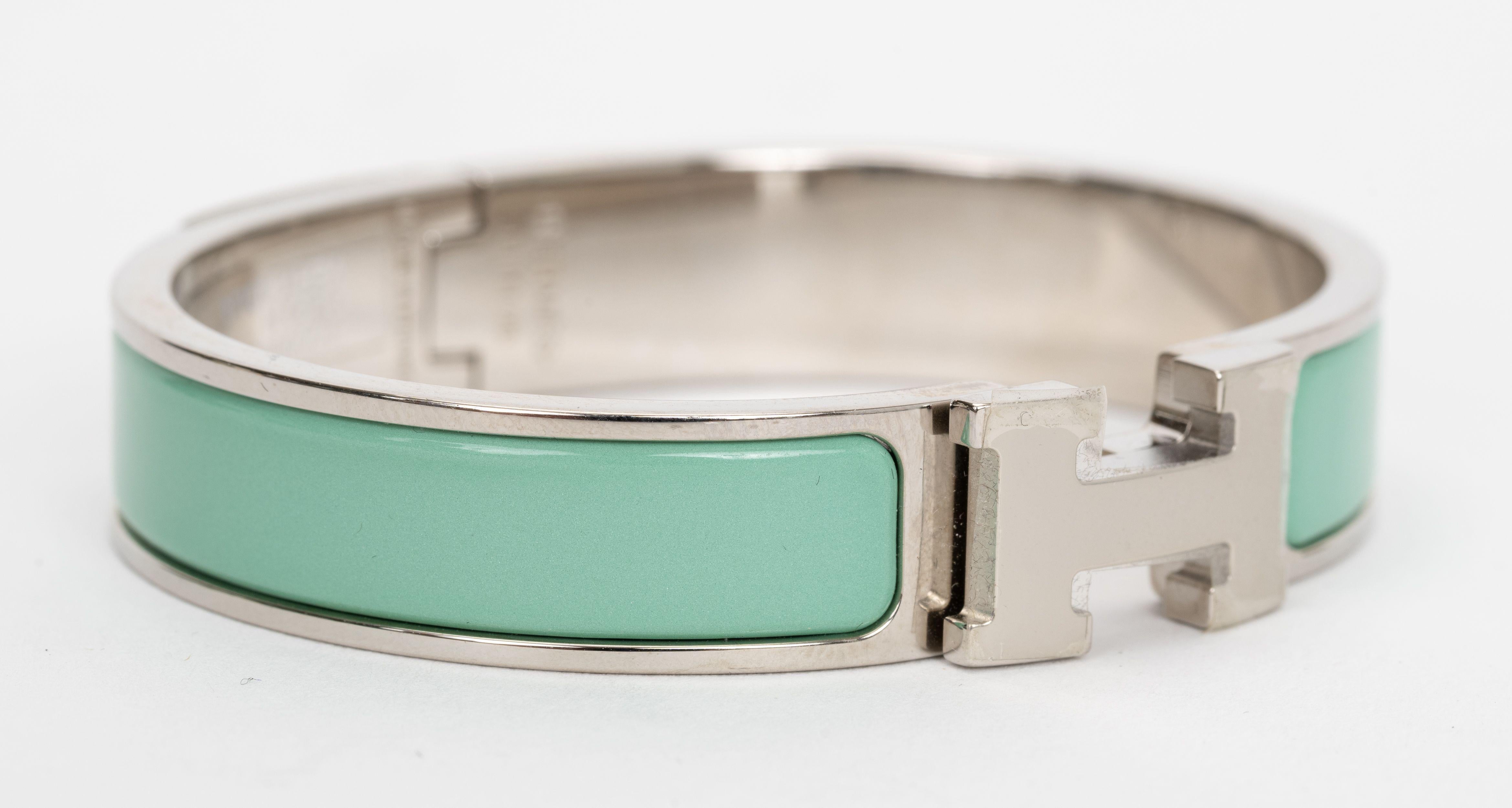 El Hermes Clic Clac H, brazalete estrecho, en esmalte verde claro con herrajes paladiados.
Talla PM, nueva sin estrenar, viene con bolsa de terciopelo.