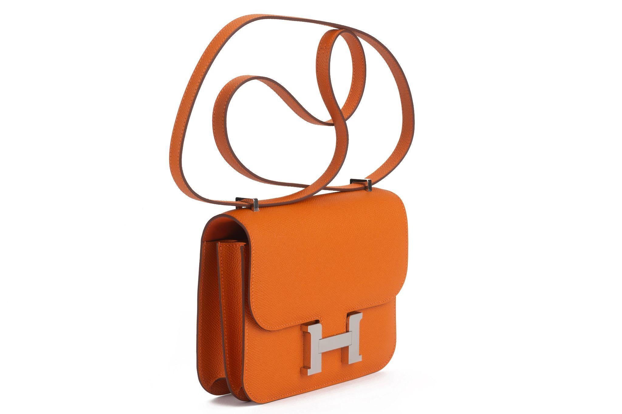 Hermes Constance Leather Handbag is your perfect small chic bag featuring orange epsom leather, shoulder strap, a front flap and palladium H logo hardware. Date stamp B. Comes with mirror, felt, booklet, original dustcover and box. Brand new in