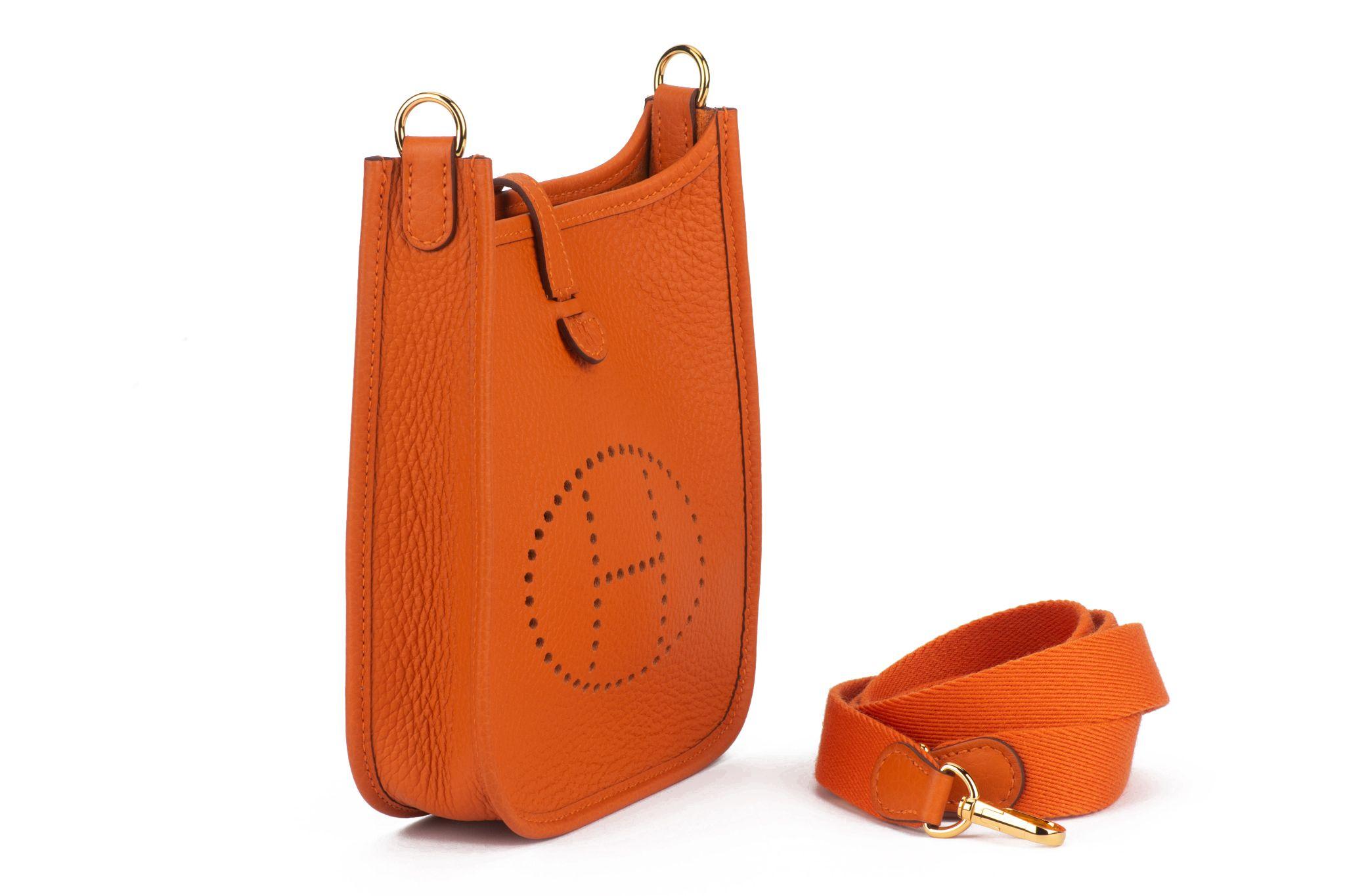 The Hermès mini Evelyne shoulder bag in orange clemence leather and gold plated hardware, with one removable strap, can be worn on the shoulder or across the body. 
Date stamp W for 2024.
Brand new , comes with ribbon, double dustcover, booklet and