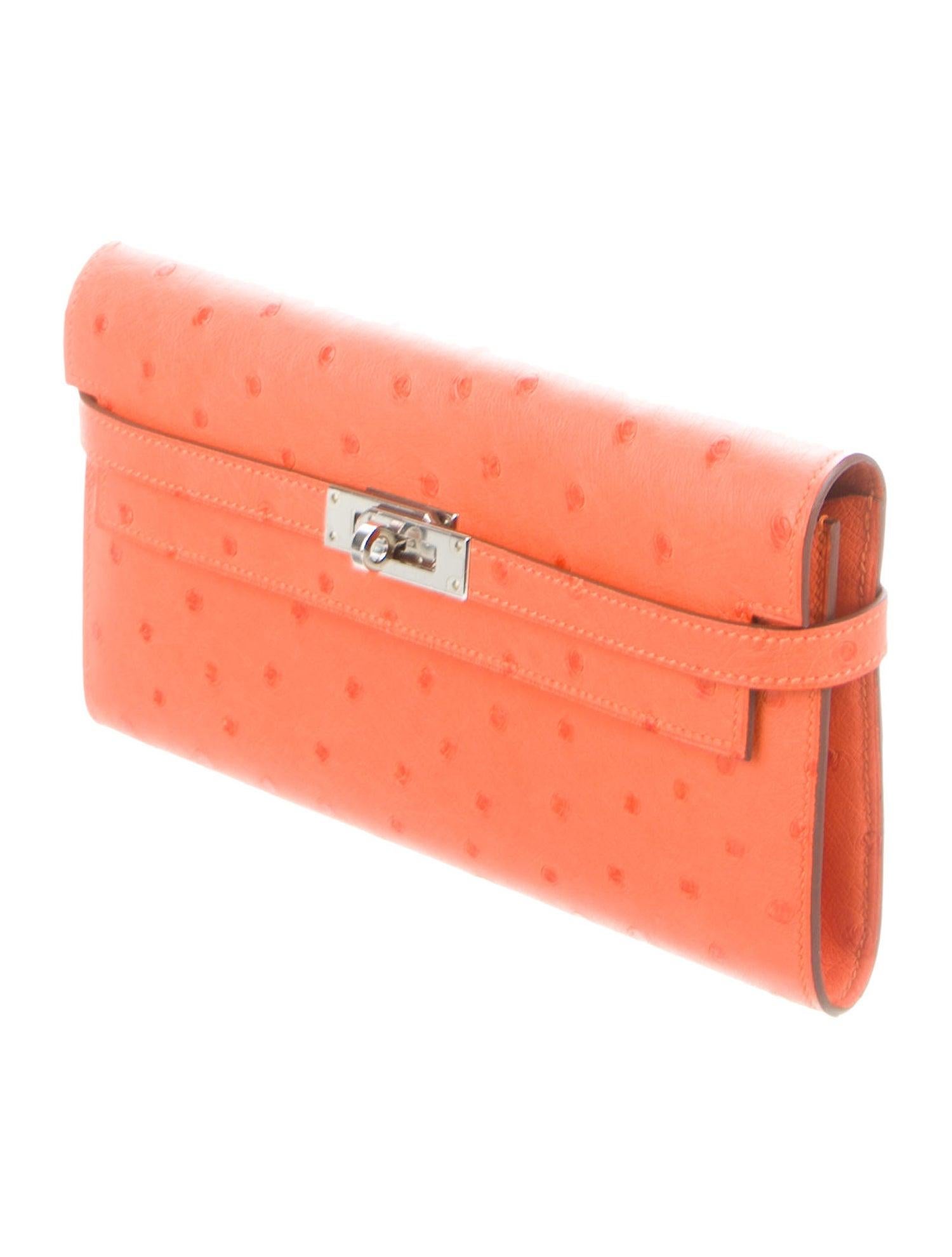 Hermes NEW Orange Ostrich Exotic Leather Kelly Palladium Evening Clutch Wallet in Box

Ostrich 
Palladium hardware
Leather lining
Turnlock closure
Features 12 card slots
Measures 8
