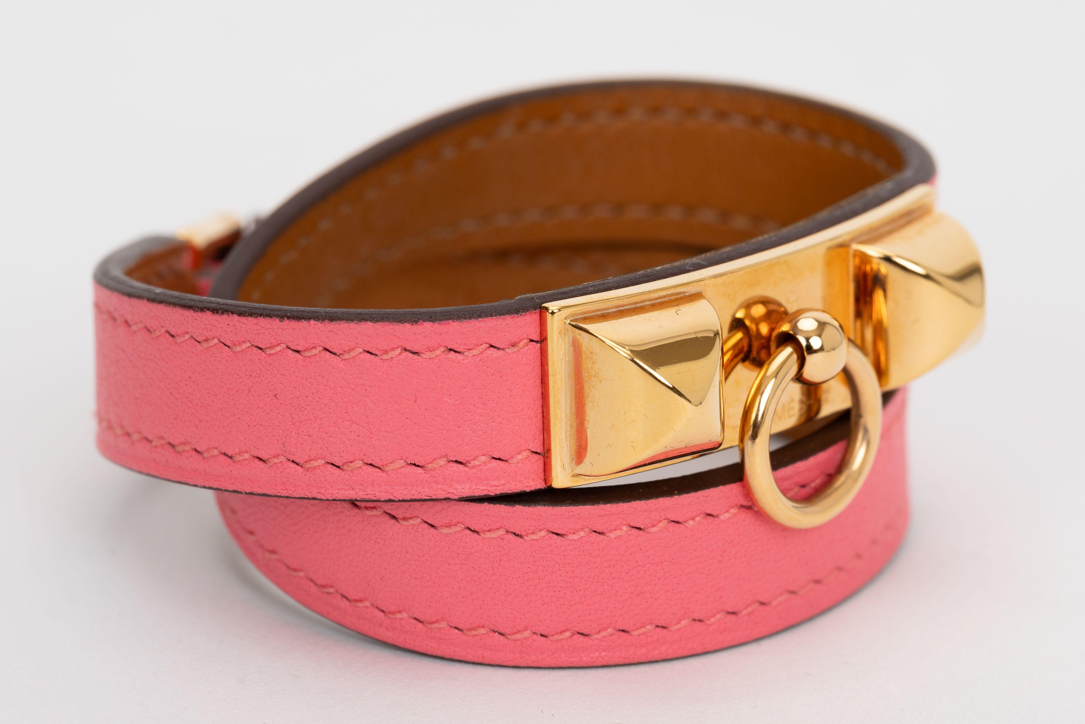 The Hermes rose azalee Swift Rivale Double Tour Bracelet features a swivel closure, Medor studs and rose gold hardware. Size extra small, date stamp A. Comes with original box.