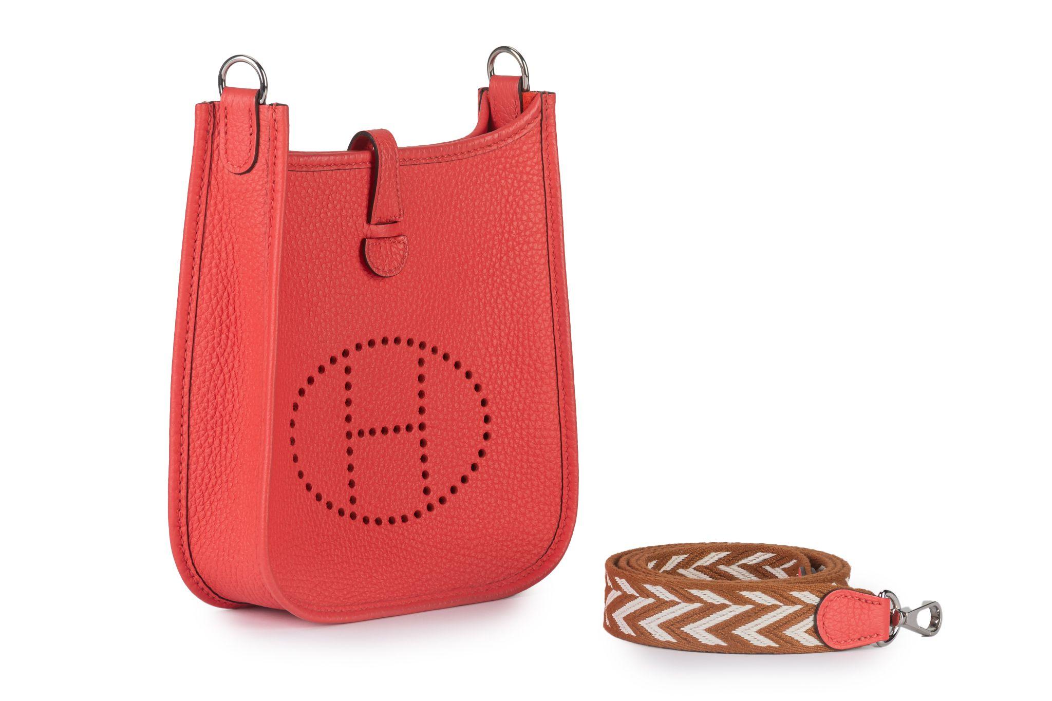 Questa borsa Hermès Mini Evelyne è caratterizzata da pelle rouge pivoine Clemence, finiture in palladio, tracolla piatta staccabile in contrasto di colore, parte superiore aperta con chiusura a sacchetto e logo H. H. traforato sul davanti.
Viene
