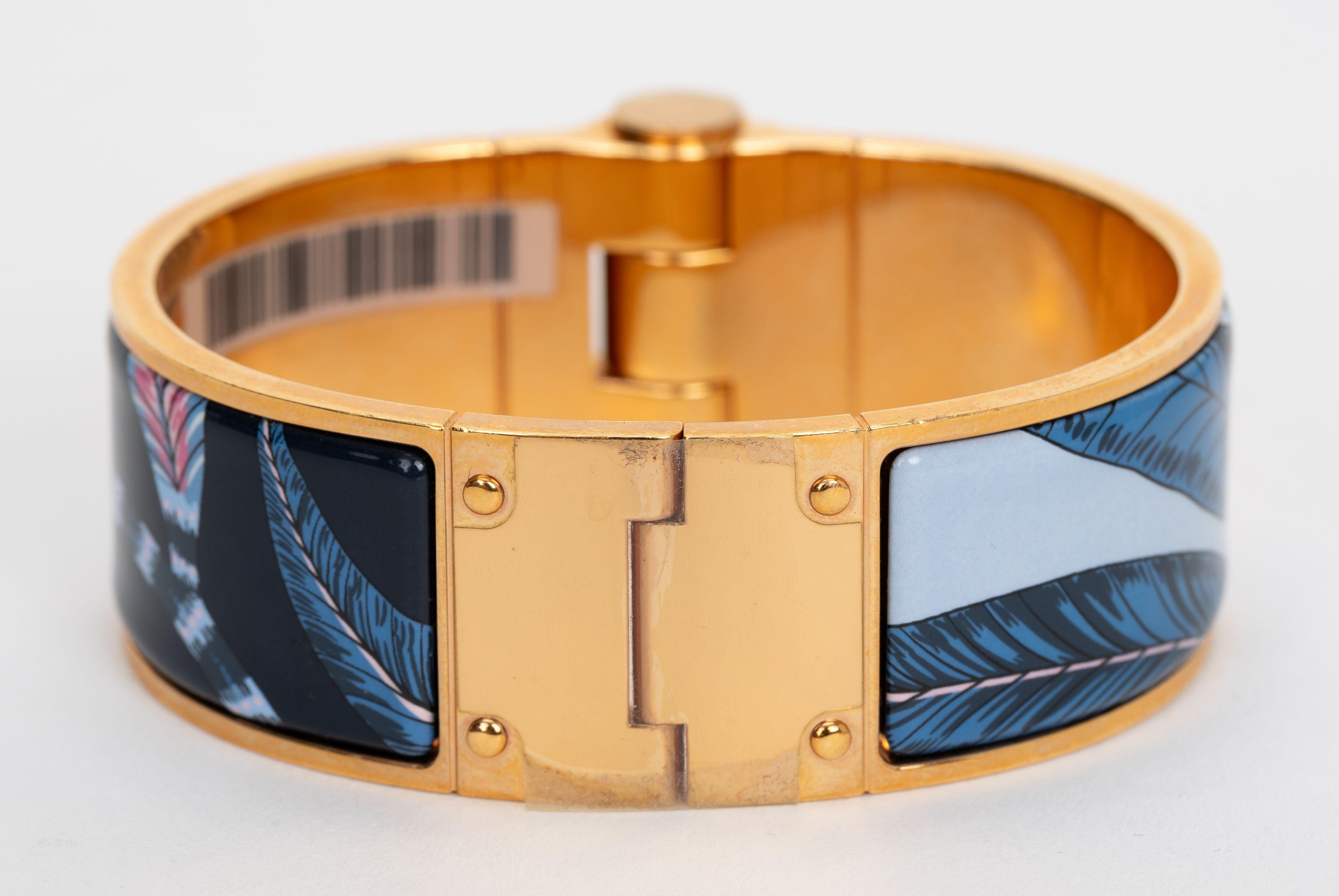 The Hermes Rose Gold Plated Savana Dance Enamel Hinged Bangle Bracelet features a floral and leaf motif of pastel colors. Size PM. Interior circumference 7.5