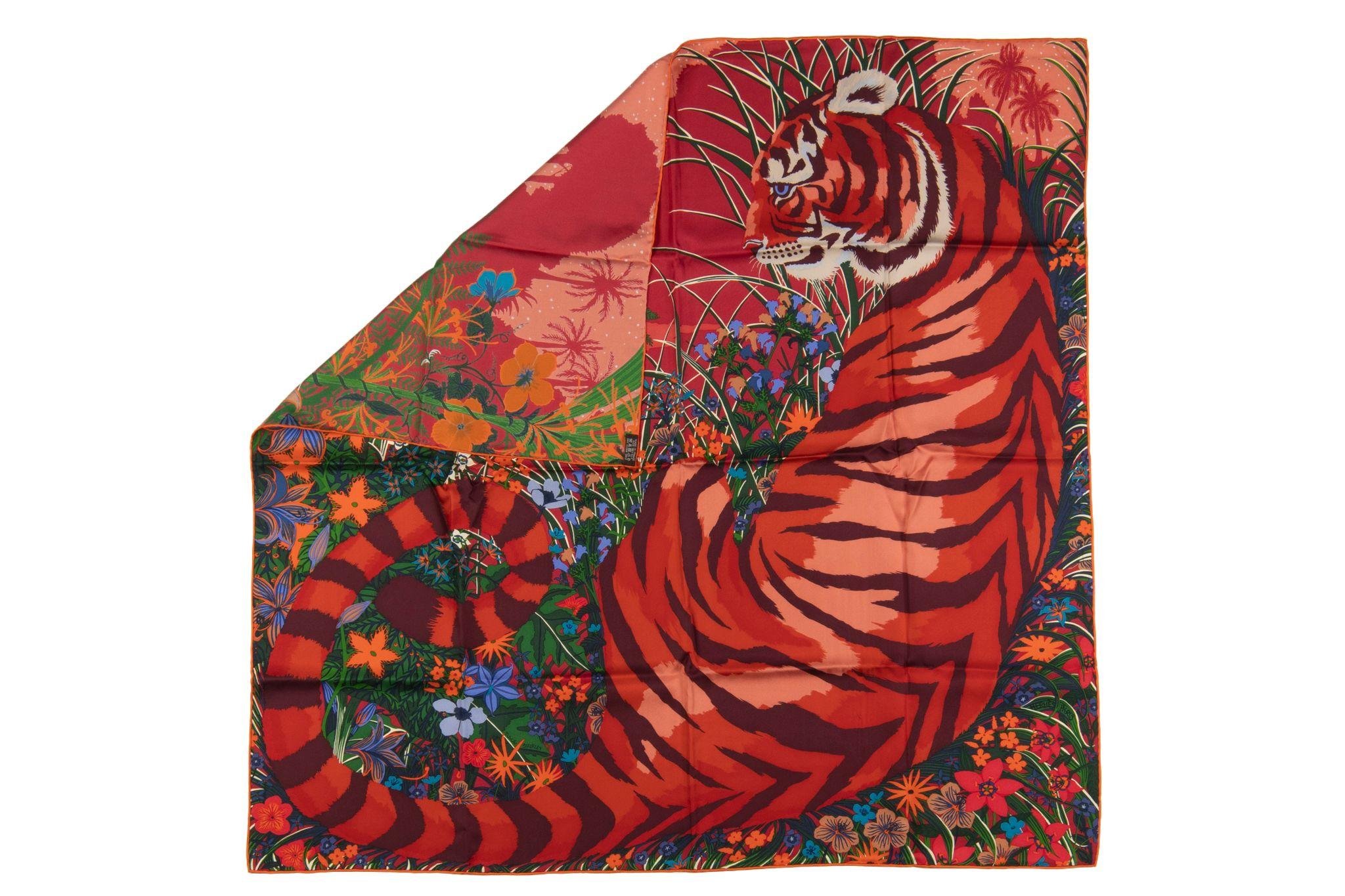 Cette écharpe Hermès Tyger Tyger 90 se décline en Saumon, Corail et Vert. Cette écharpe est 100 % soie et présente un motif multicolore représentant un tigre dans un décor de jungle.