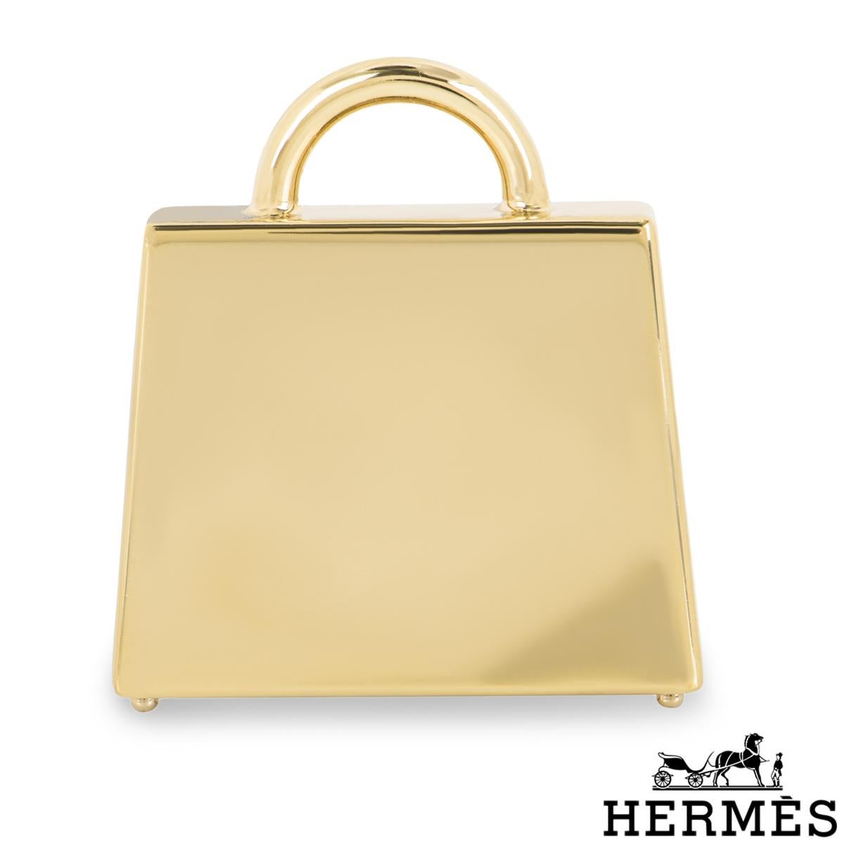 A chic Hermès Kelly Bag charm. The charm features a Curiosite Noir Laque Kelly motif with permabrass plated hardware. This versatile charm can be worn as a pendant or on an Hermès Twilly as a charm.

The charm measures 28mm L X 30mm H X 7.5mm