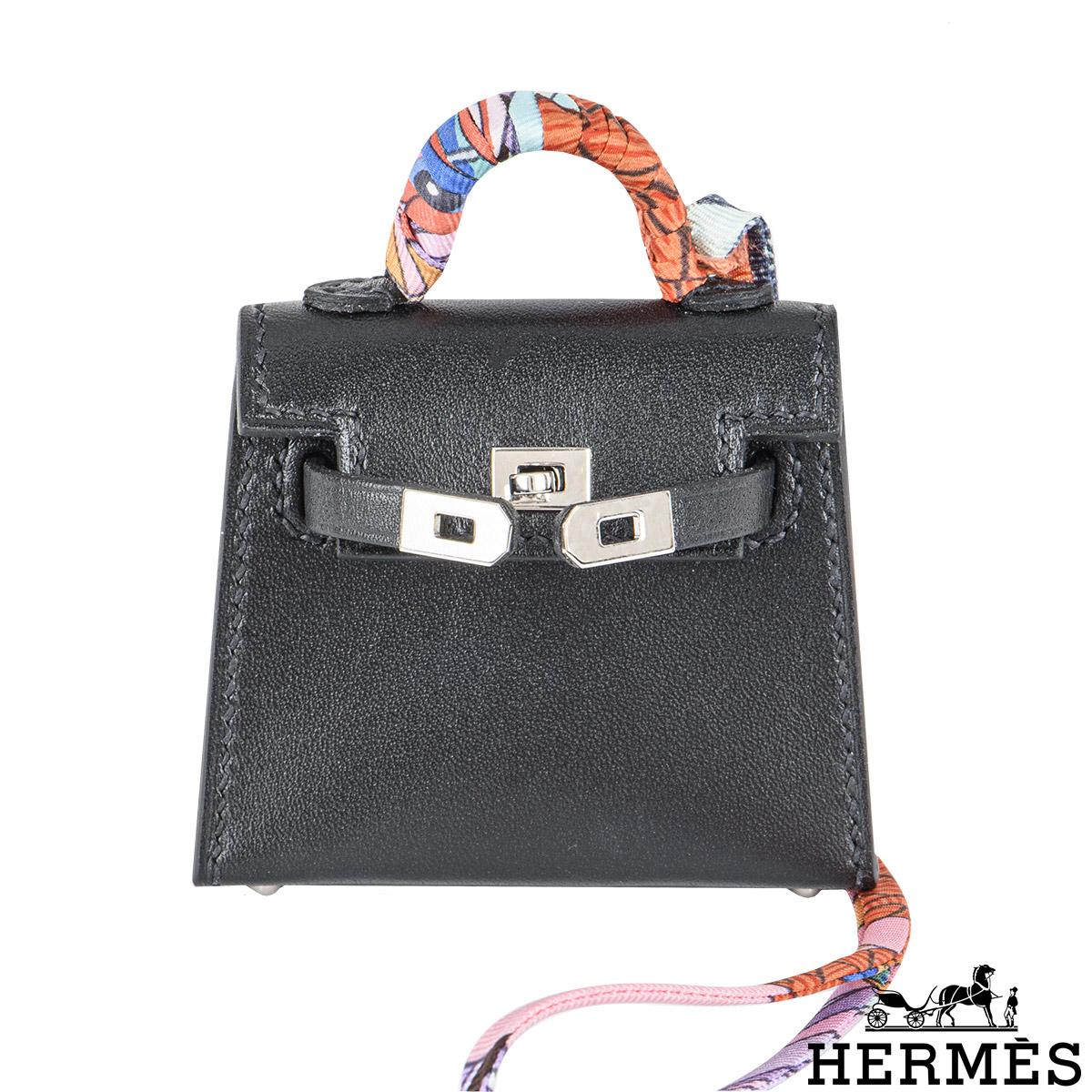 A chic Hermès Mini Kelly Twilly bag charm. The exterior of this Kelly bag charm features a Noir Tadelakt leather detailed with tonal stitching. It features palladium hardware with a front toggle closure, and a top handle wrapped with a multicoloured