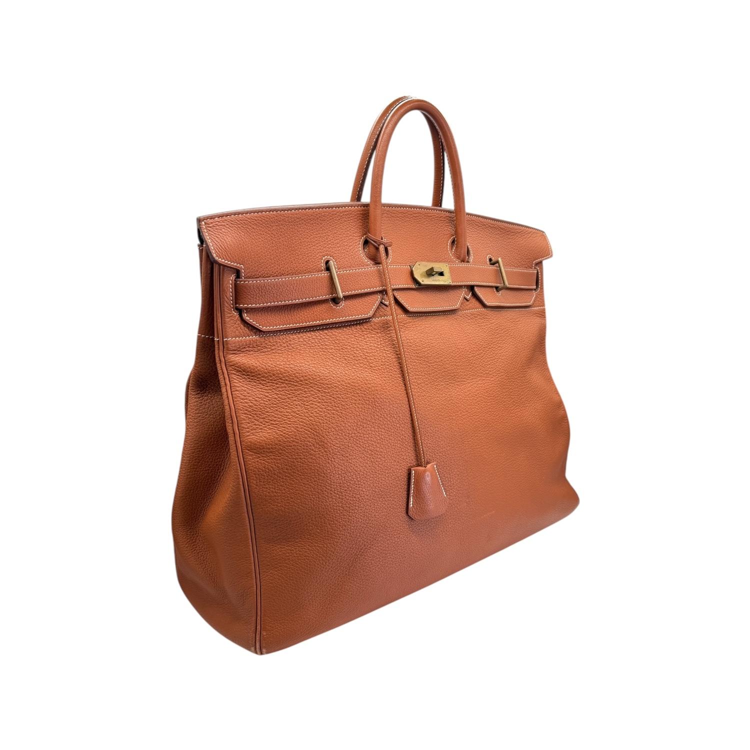 Indulge in luxury with the Hermès Noisette Clemence HAC Birkin 50 Men's Bag. Handcrafted in France from rich Clemence leather, this bag features gold plated hardware and a pull-through closure with turn lock for added security. Its spacious size and