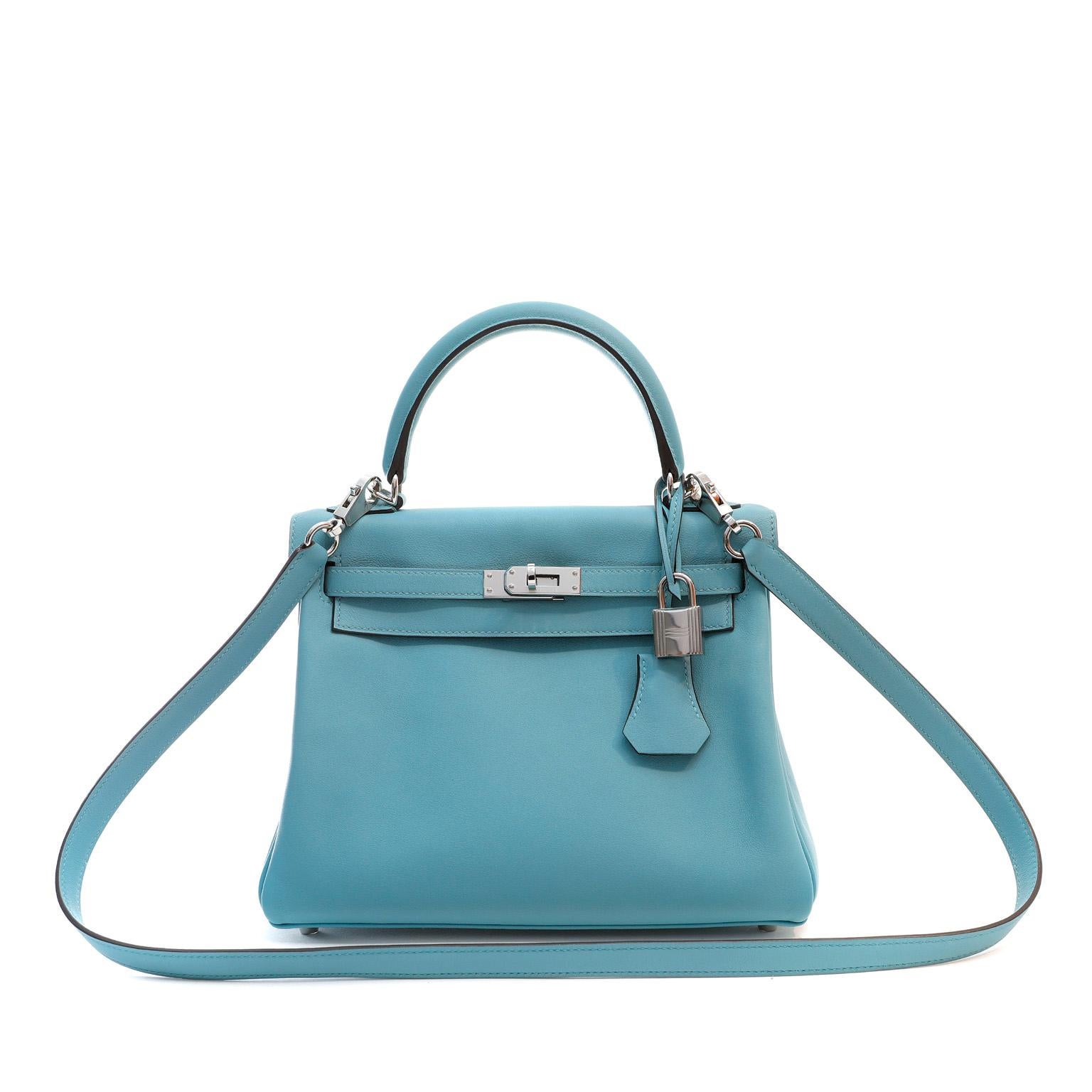 This authentic Hermès Ocean Blue Swift Leather 25 cm Kelly is in pristine unworn condition with the protective plastic intact on the hardware.

Long waitlists are commonplace for the intensely coveted iconic Kelly.  Each piece is hand crafted by
