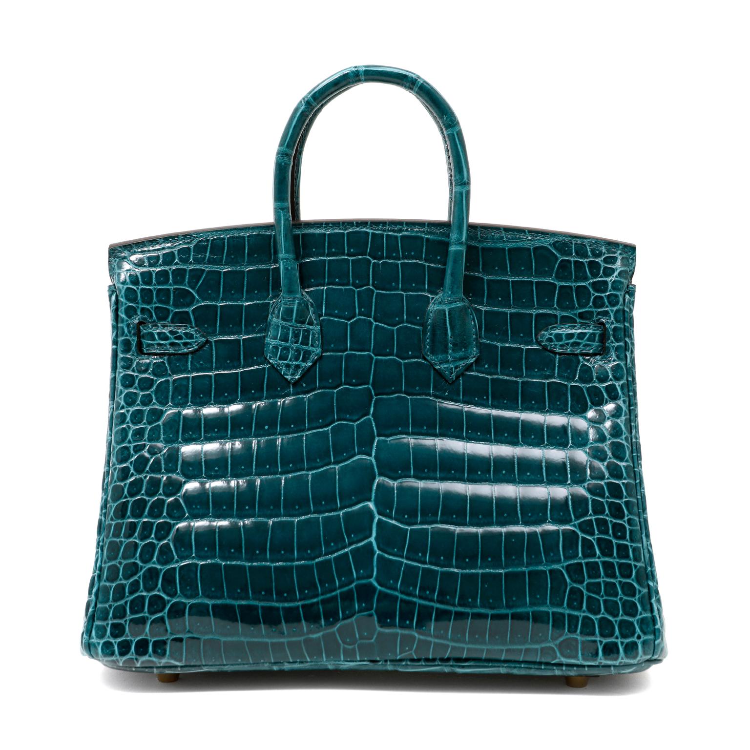 This authentic Hermès Green Porosus Crocodile 25 cm Birkin is in pristine unworn condition with the protective plastic intact on the hardware.  Considered by many to be the premier Hermès skin, Porosus crocodile is characterized by a symmetrical