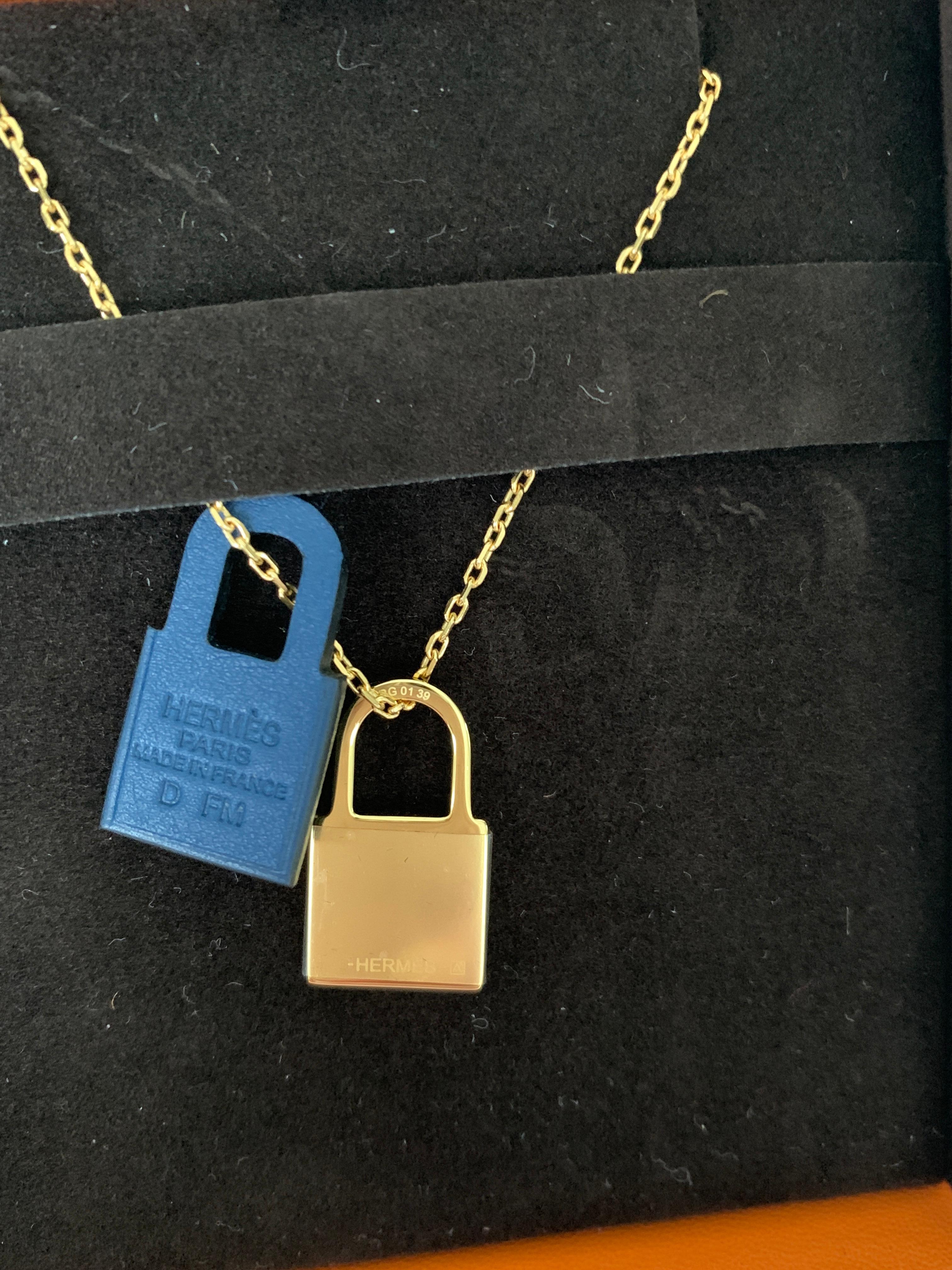 Hermes O'Kelly Pendant Necklace
Small Model
Deep Blue
Pendant in Swift calfskin with gold plated hardware.
The O’Kelly story gives pride of place to the eponymous bag’s padlock. Here, it is slimmed down and attached to a stylized leather padlock