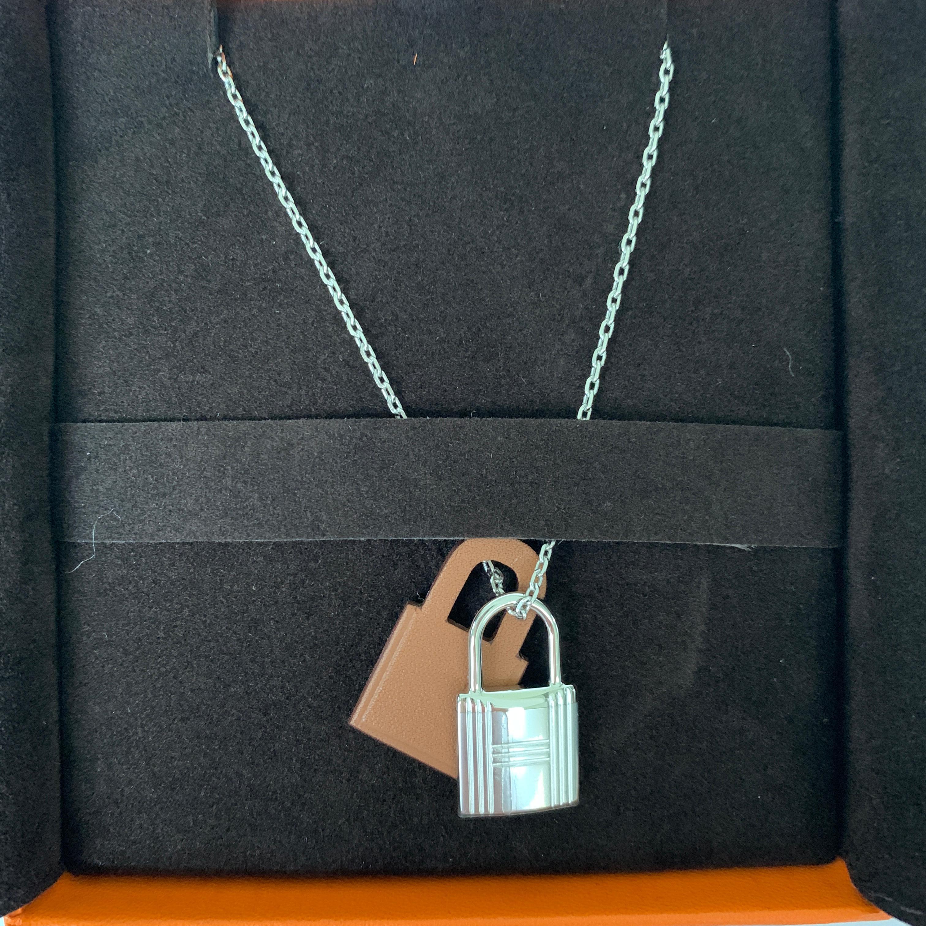 Hermes O'Kelly Pendant Necklace
Small Model
Gold
Pendant in Swift calfskin with palladium plated hardware.
The O’Kelly story gives pride of place to the eponymous bag’s padlock. Here, it is slimmed down and attached to a stylized leather padlock