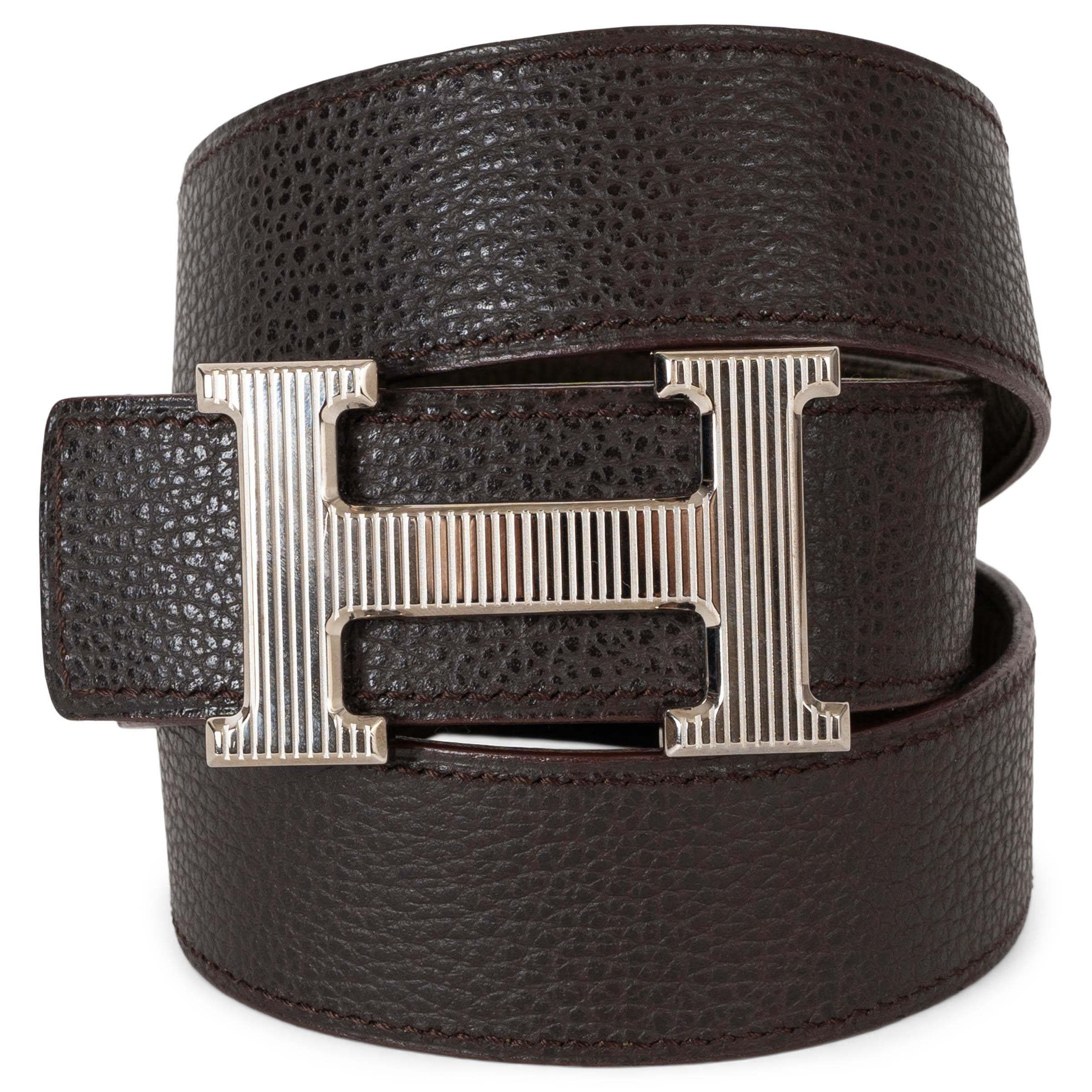 This 100% authentic Hermès reversible belt in Vert Bronze (dark sage green) Veau Eversoft nubuck and dark brown Veau Togo leather offers versatile sophistication. Featuring a palladium H-Striée buckle, it seamlessly transitions between two refined