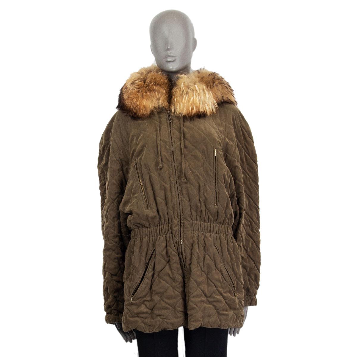 Hermes quilted oversized fox fur trim hood jacket in olive green polyester (85%) and polyamide (15%). Has four zipped pockets at the front and an elastic waist band to emphasize the silhouette. Opens with a zipper on the front. Lined in olive green