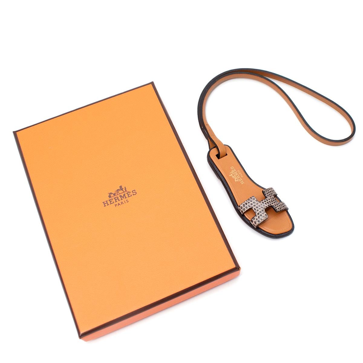 Hermes Oran Nano Ombre Charm 

- A new miniaturization of an Hermès icon, borrowed from the shoe universe.
- Crafted in natural sable butler leather with an ombre lizard skin H Cut-Out
- 