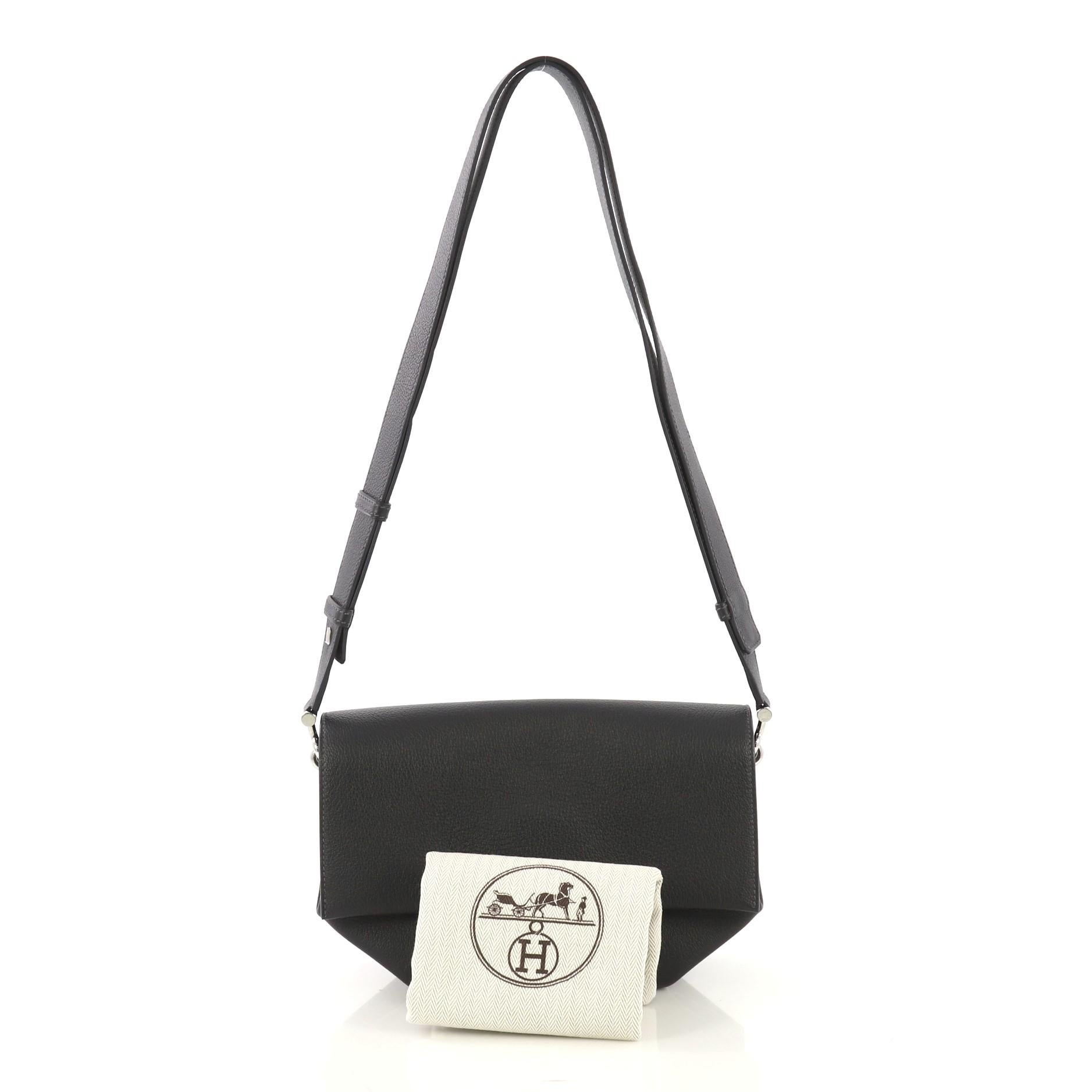 This Hermes Opli Bag Novillo 24, crafted from Bleu Indigo Novillo leather, features an adjustable strap and palladium hardware. Its flap with snap closure opens to an Orange Poppy Chevre Leather interior with three open compartments. Date stamp