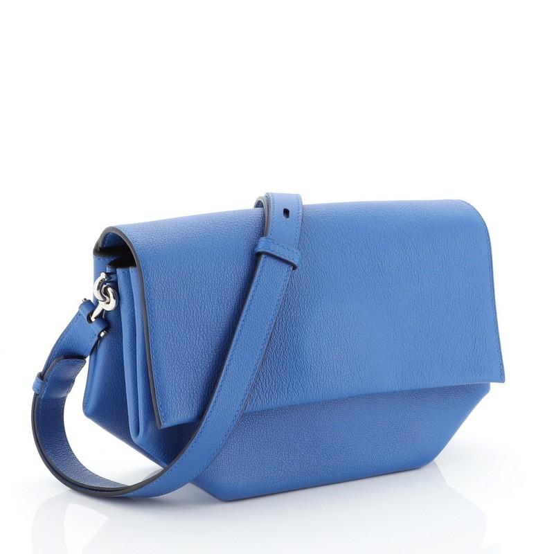 This Hermes Opli Bag Novillo 24, crafted from Bleu Zellige blue Novillo leather, features an adjustable strap and palladium hardware. Its flap with snap closure opens to a Bleu Encre blue leather interior with three open compartments. Date stamp