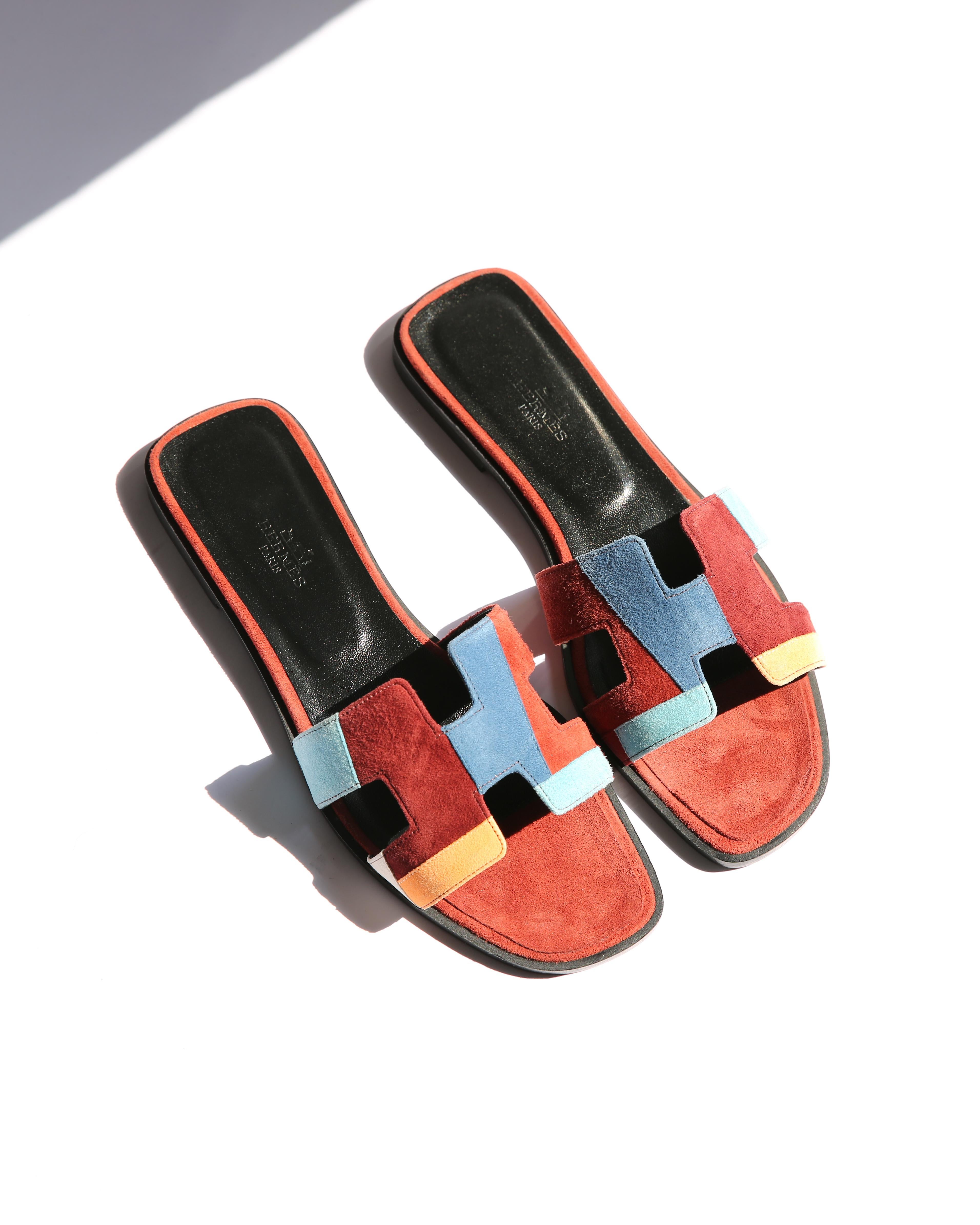 Hermes limited edition Oran sandals in burgundy, blue, grey and peach suede geometric print 
Black wood heel with leather sole 

Size:
EU 39
US 9
UK 6

Condition: 
In excellent condition. These have only been tried on with in the home, so the soles