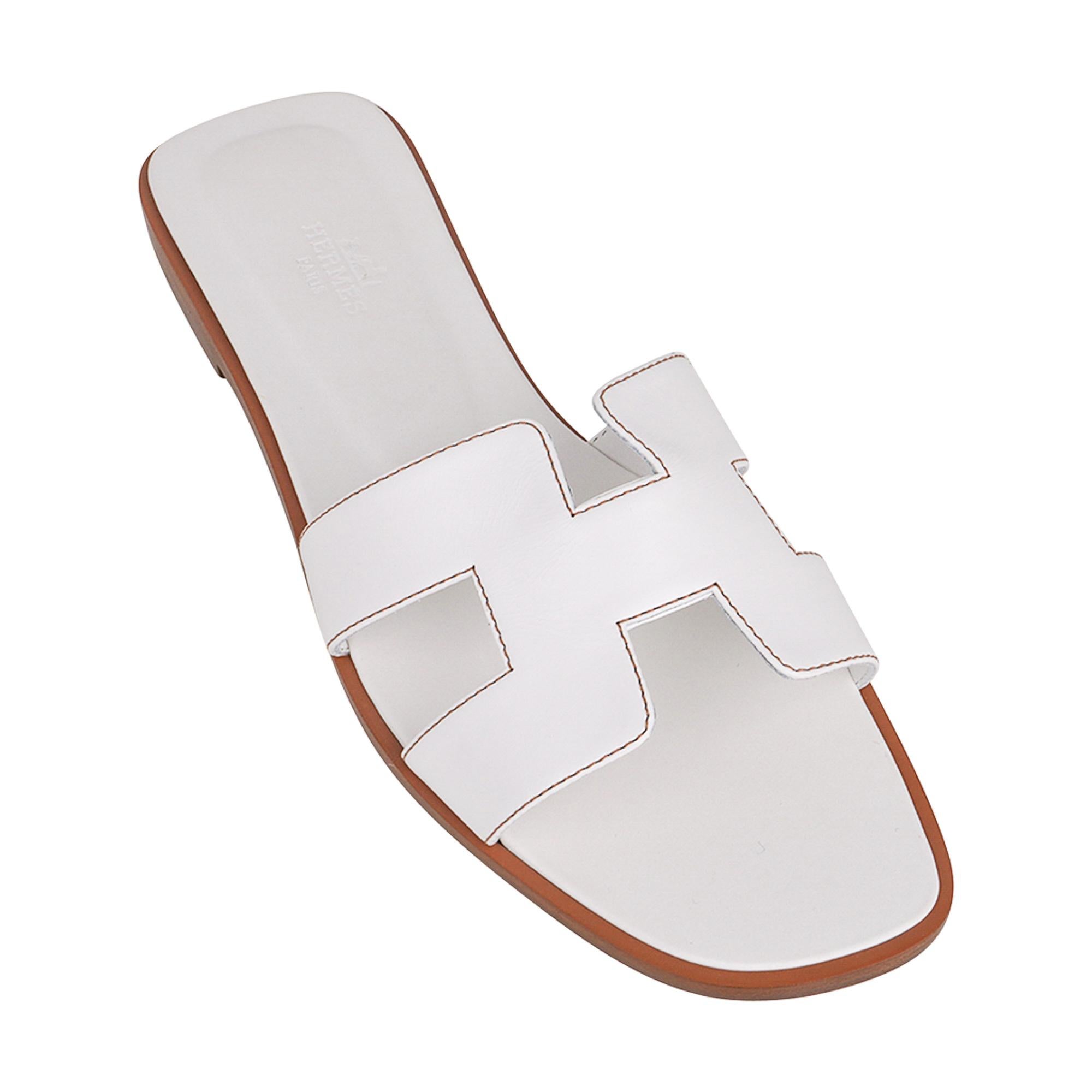 Mightychic offers a guaranteed authentic Hermes Oran White leather sandals.
The iconic top stitched H cutout over the top of the foot.
This Hermes Oran slide shoe is accentuated with Havane topstitch.
Natural wood heel with leather sole.
Comes with