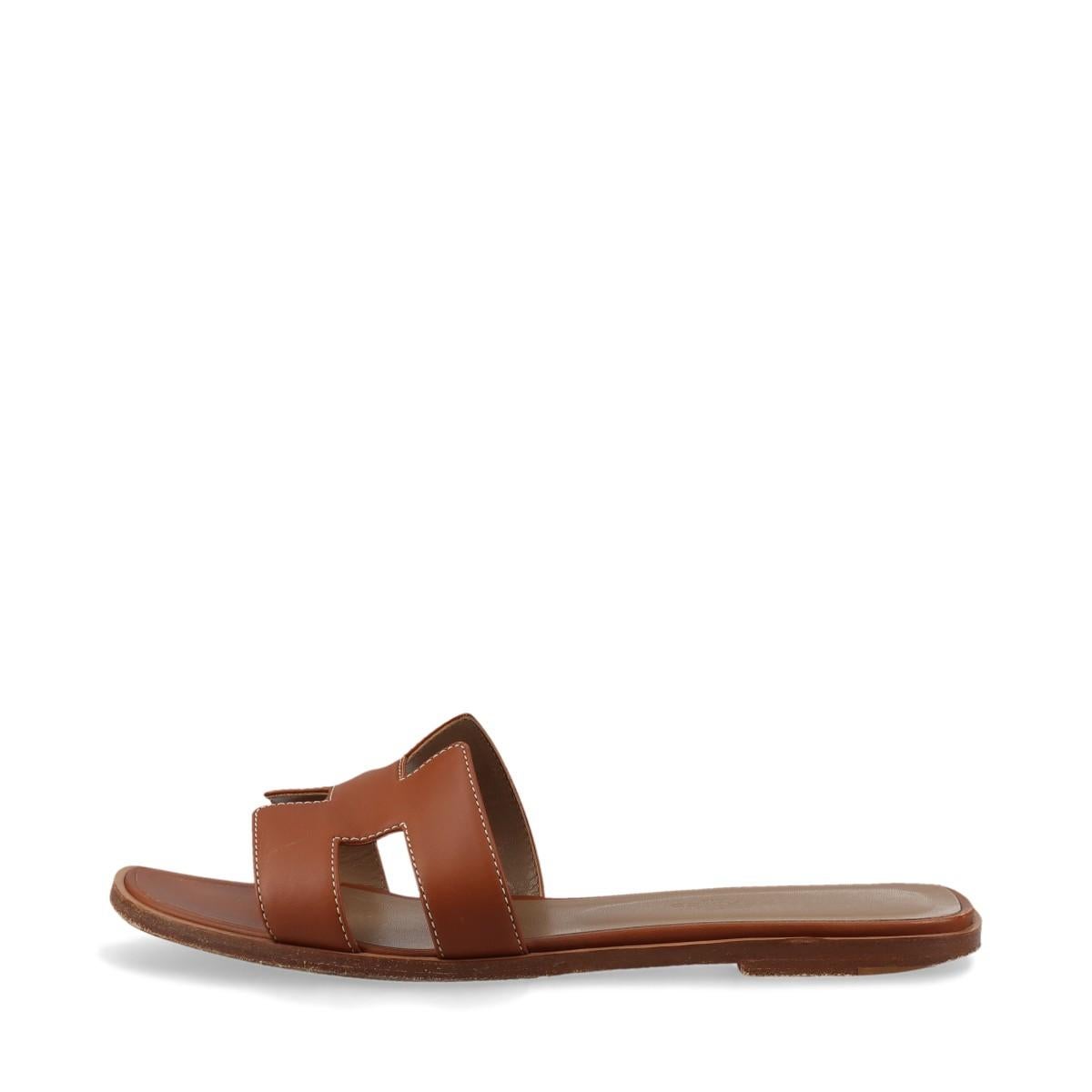 The Hermès Oran Leather Sandals in Brown are a timeless and versatile footwear choice that epitomizes understated luxury. The signature 